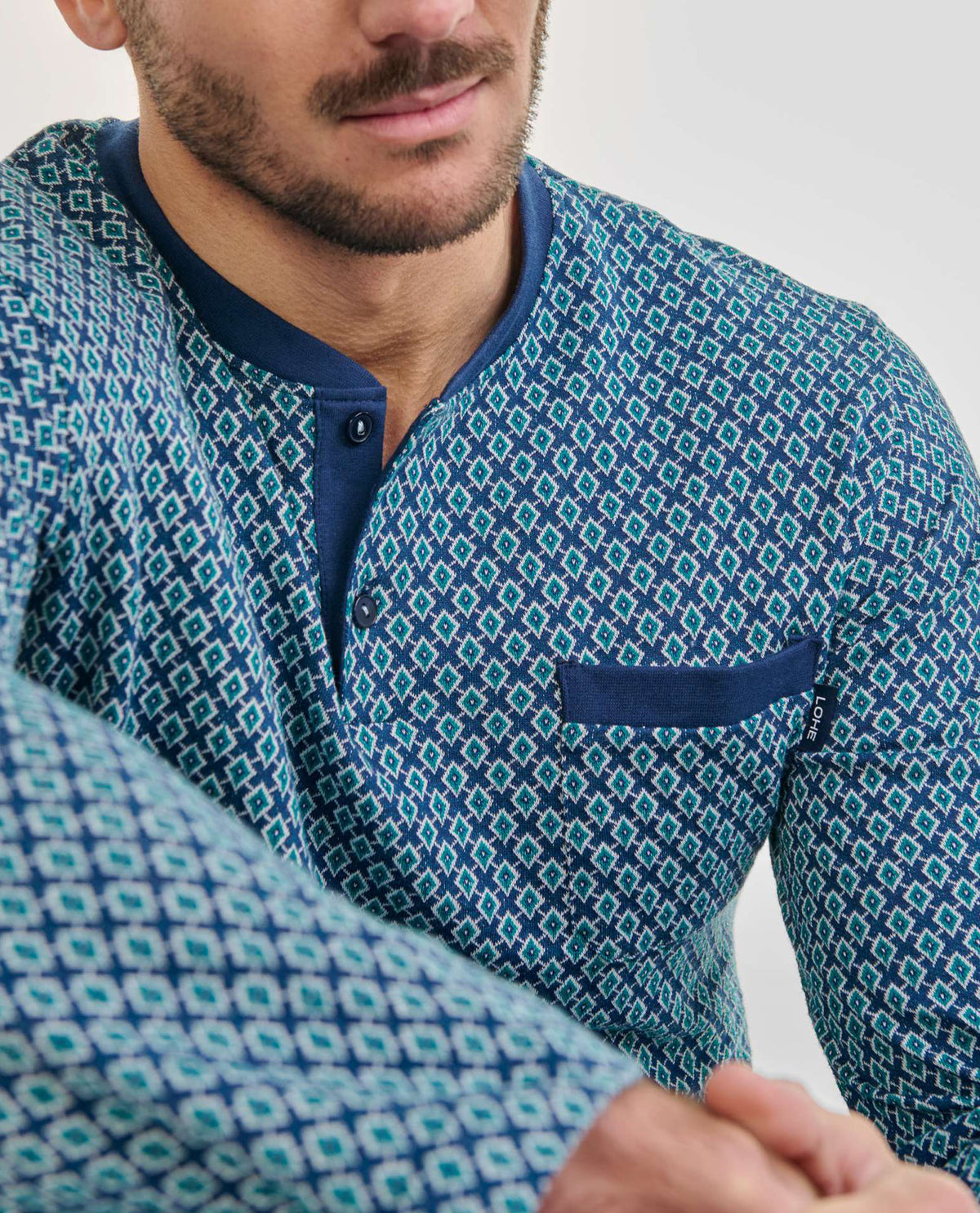 Detalle de top de pijama de caballero para invierno con cuello abierto abotonado y diseño estilo corbatero tonos azules