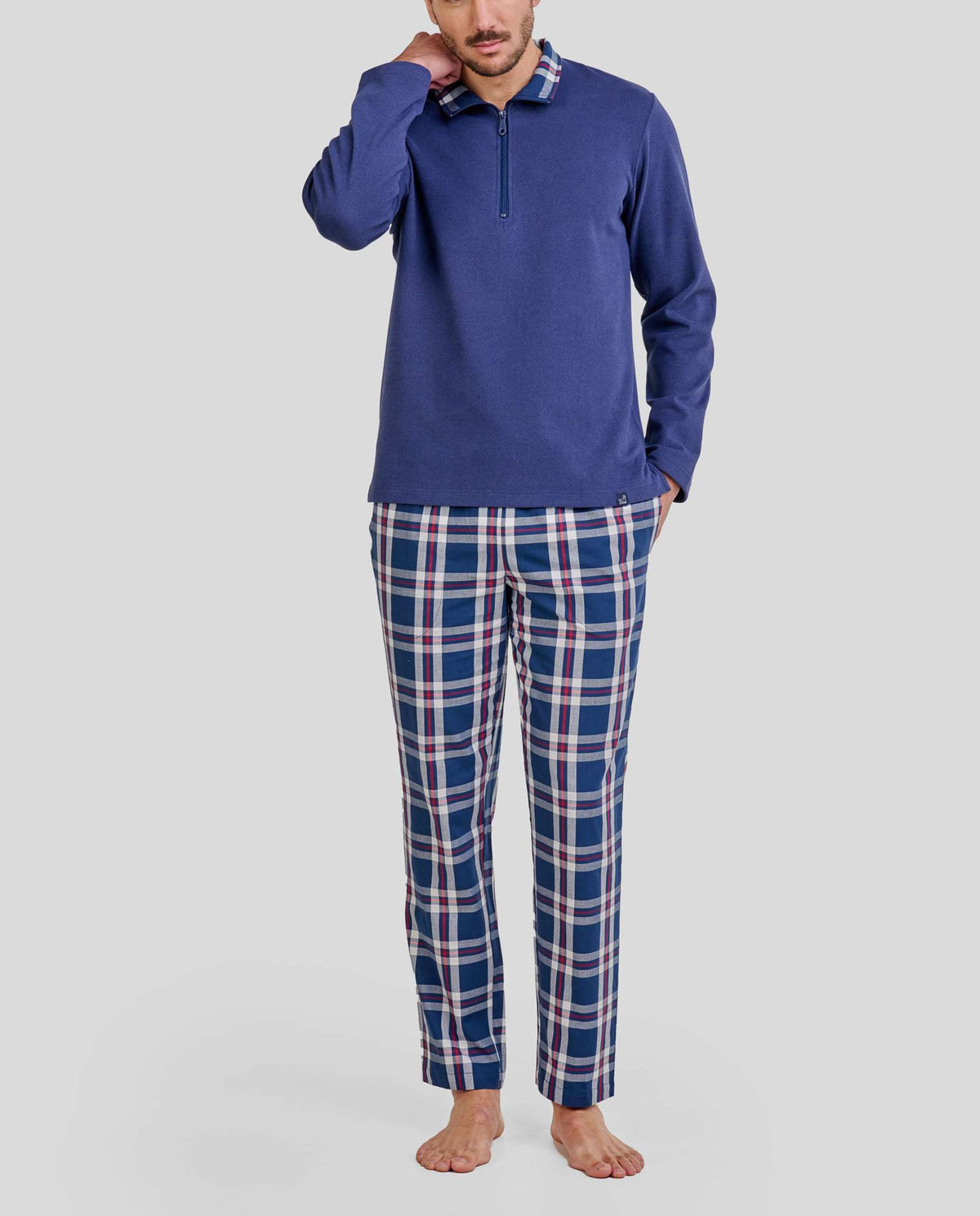 Hombre con pijama largo de invierno de chaquetilla azul con cuello cremallera y pantalón de cuadros con bolsillos