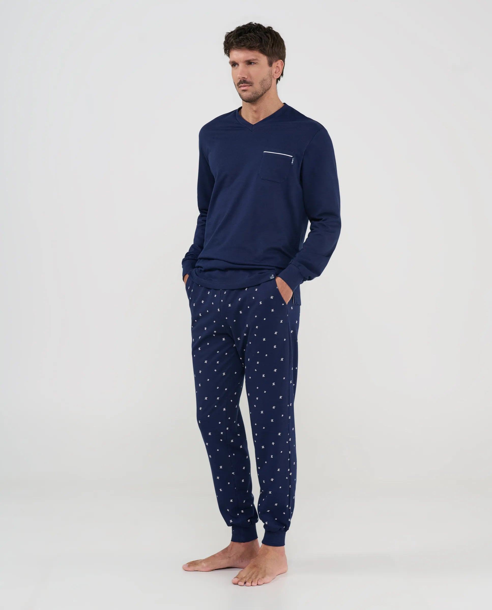 Pijama largo de hombre azul marino con chaqueta lisa y pantalón estampado de estrellas, vista frontal.