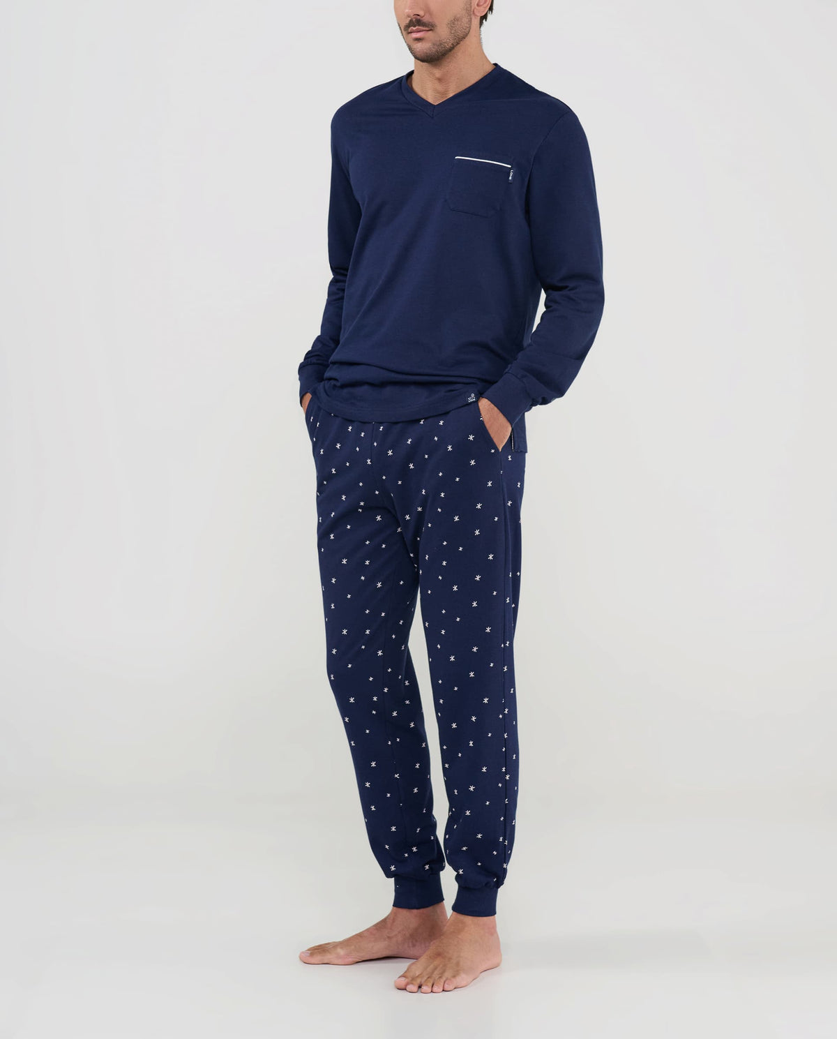 Pijama largo de hombre azul marino con chaqueta lisa y pantalón estampado de estrellas, vista frontal.