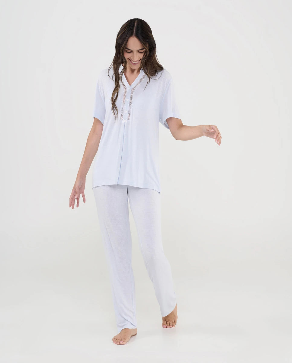Mujer con pijama lencero de verano color celeste de manga corta y pantalón largo con escote pico y detalle entredós