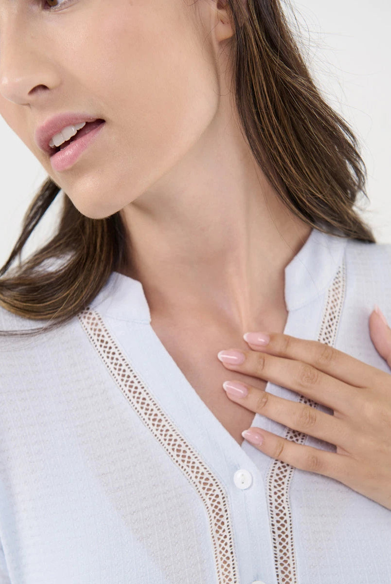 Detalle del escote en pico con entredós del pijama lencero de manga corta celeste para mujer