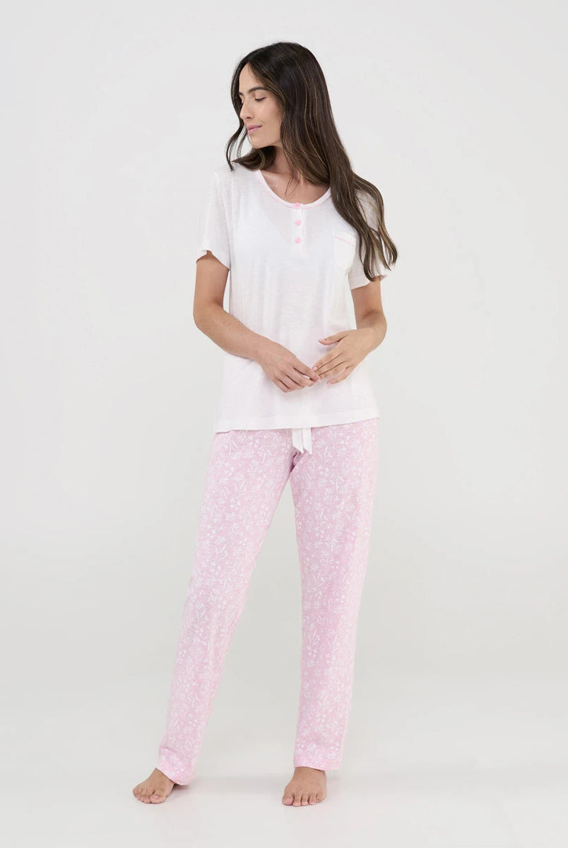 Mujer viste pijama de verano de manga corta en punto blanco y pantalón largo rosa con florecitas