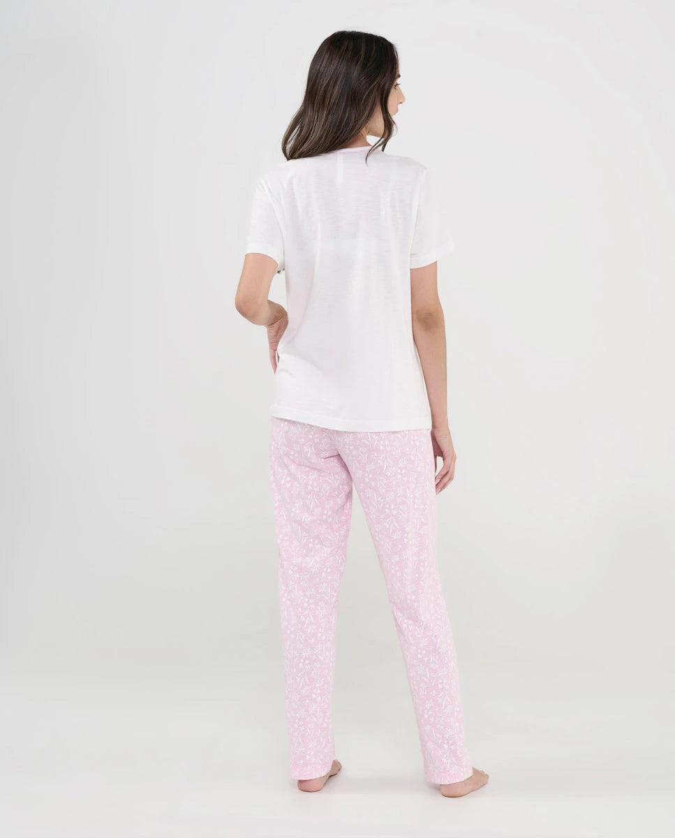 Mujer de espaldas con pijama largo de verano camiseta manga corta blanca y pantalón estampado rosa