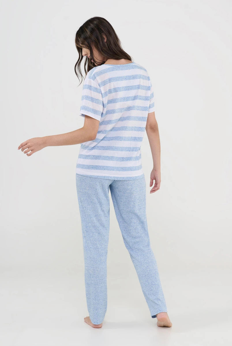 Mujer de espaldas con pijama largo de verano con camiseta celeste de rayas y pantalón liso a juego