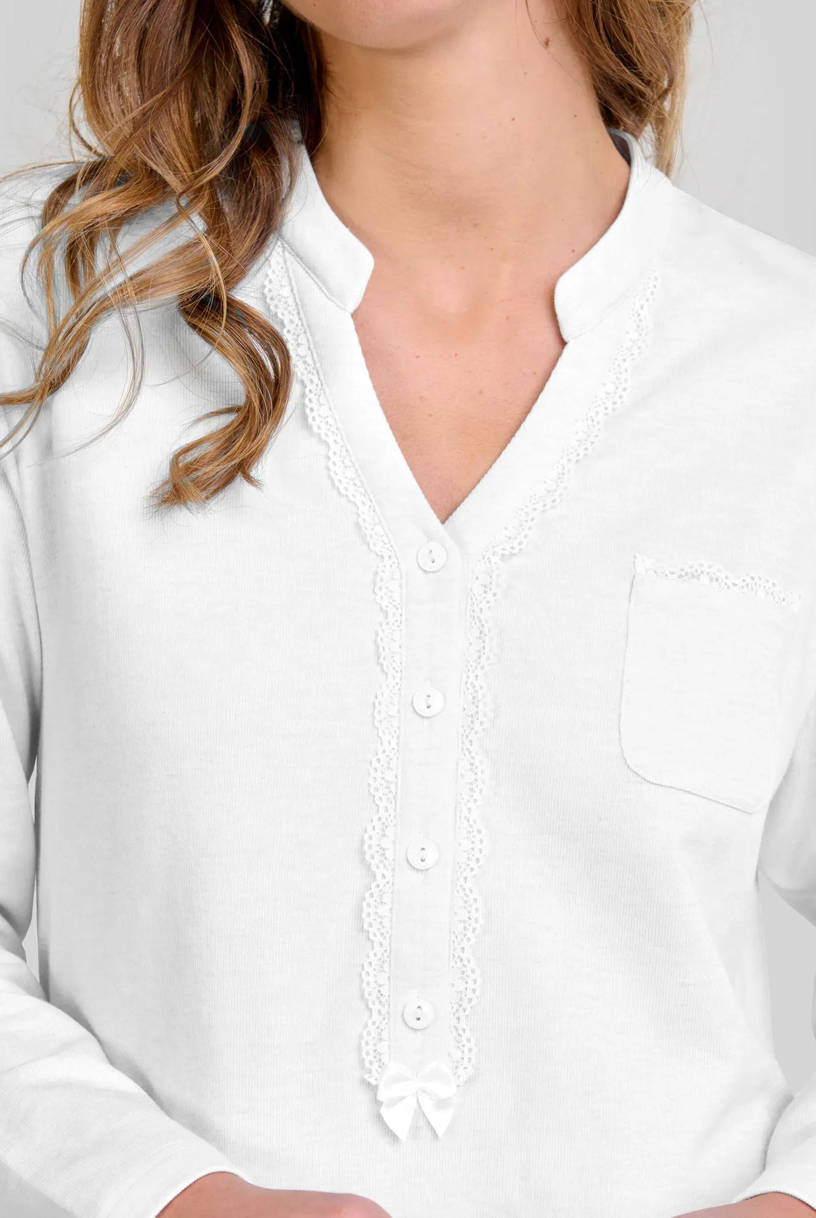 Mujer luce chaquetilla de pijama de invierno rosa de manga larga, cuello con botones blancos y lazo