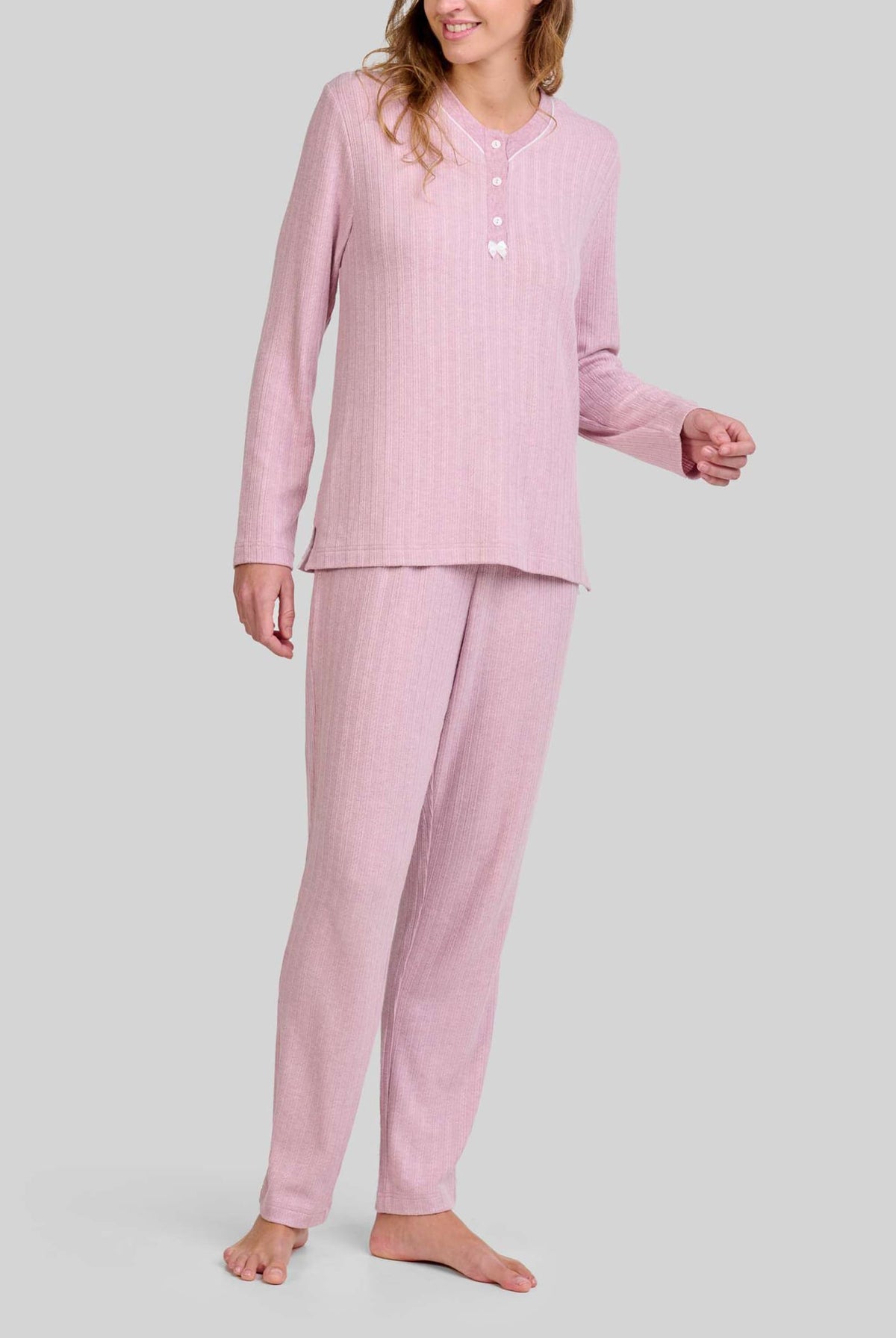Mujer con pijama rosa palo de manga larga y botones, pantalón a juego con cuello abotonado