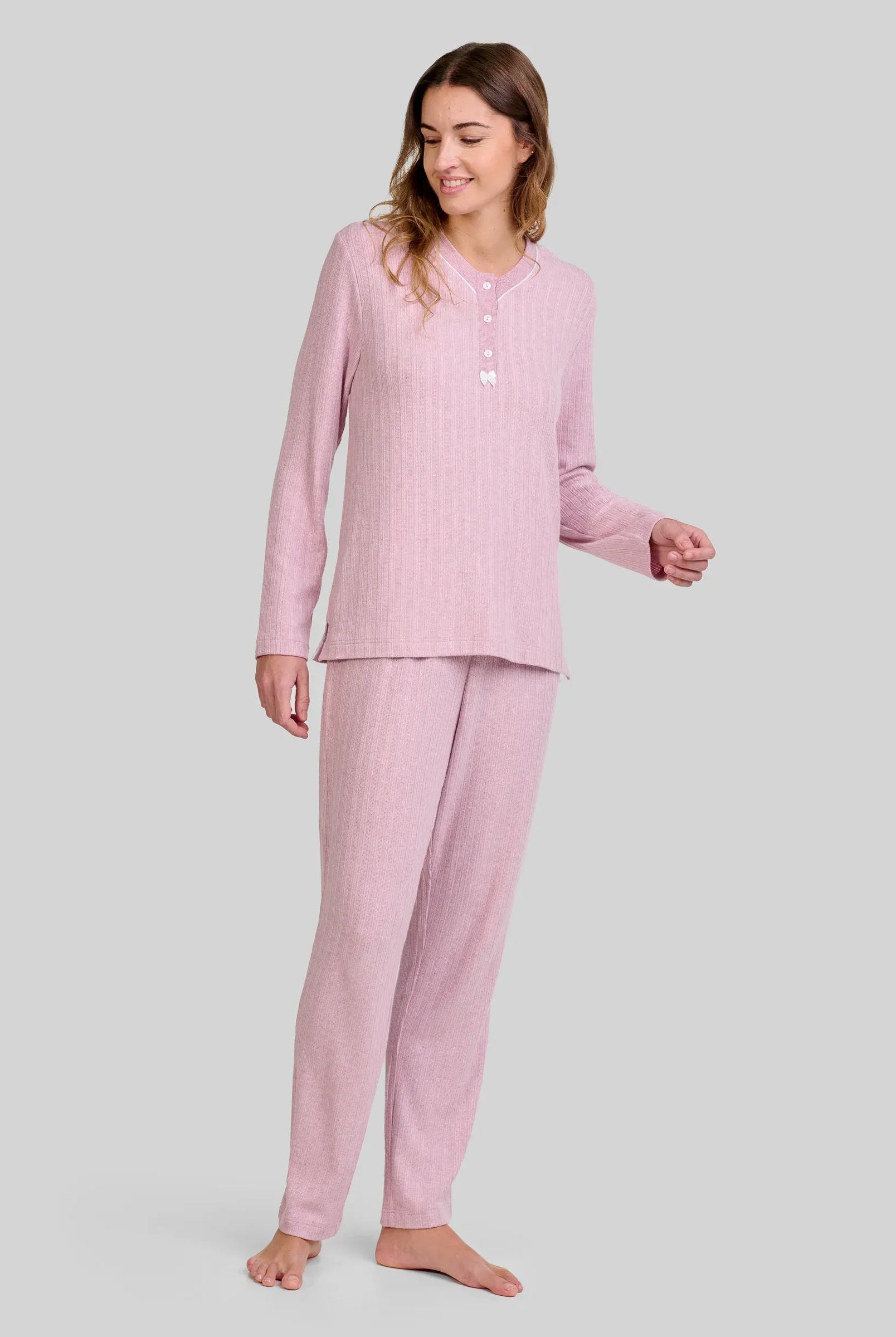 Mujer con pijama rosa palo de manga larga y botones, pantalón a juego con cuello abotonado