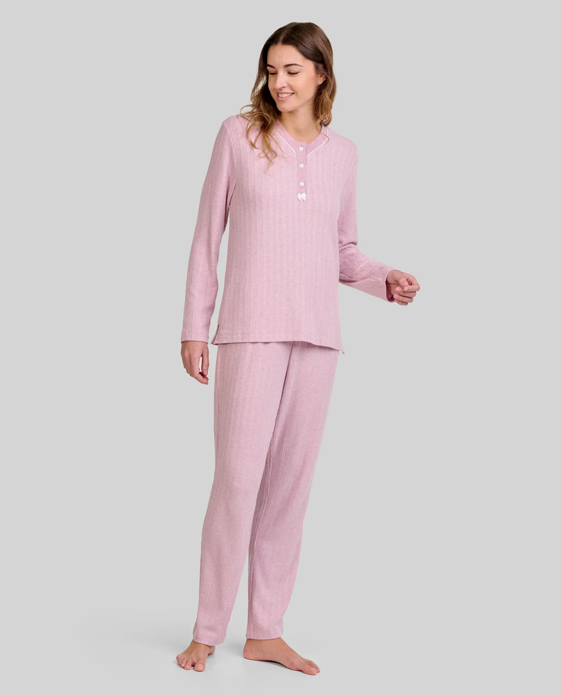 Mujer con pijama rosa palo de manga larga y botones, pantalón a juego con cuello abotonado