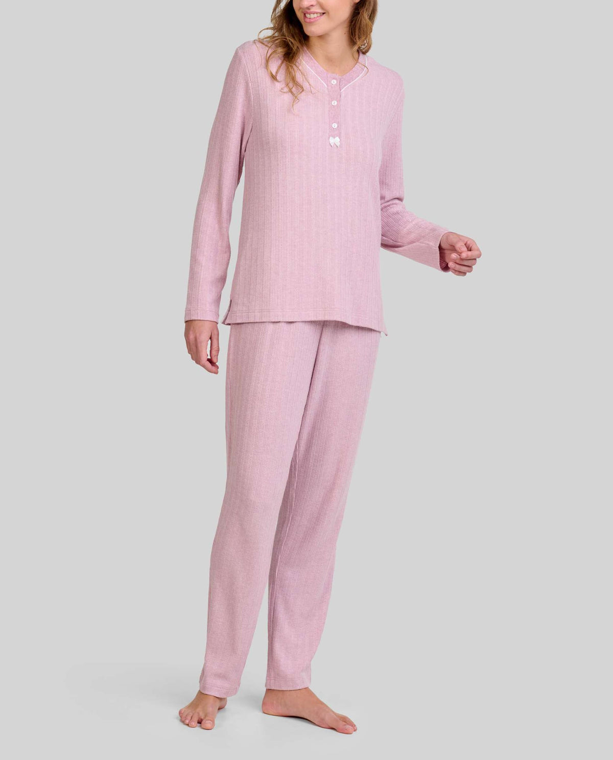 Mujer con pijama rosa palo de manga larga y botones, pantalón a juego con cuello abotonado