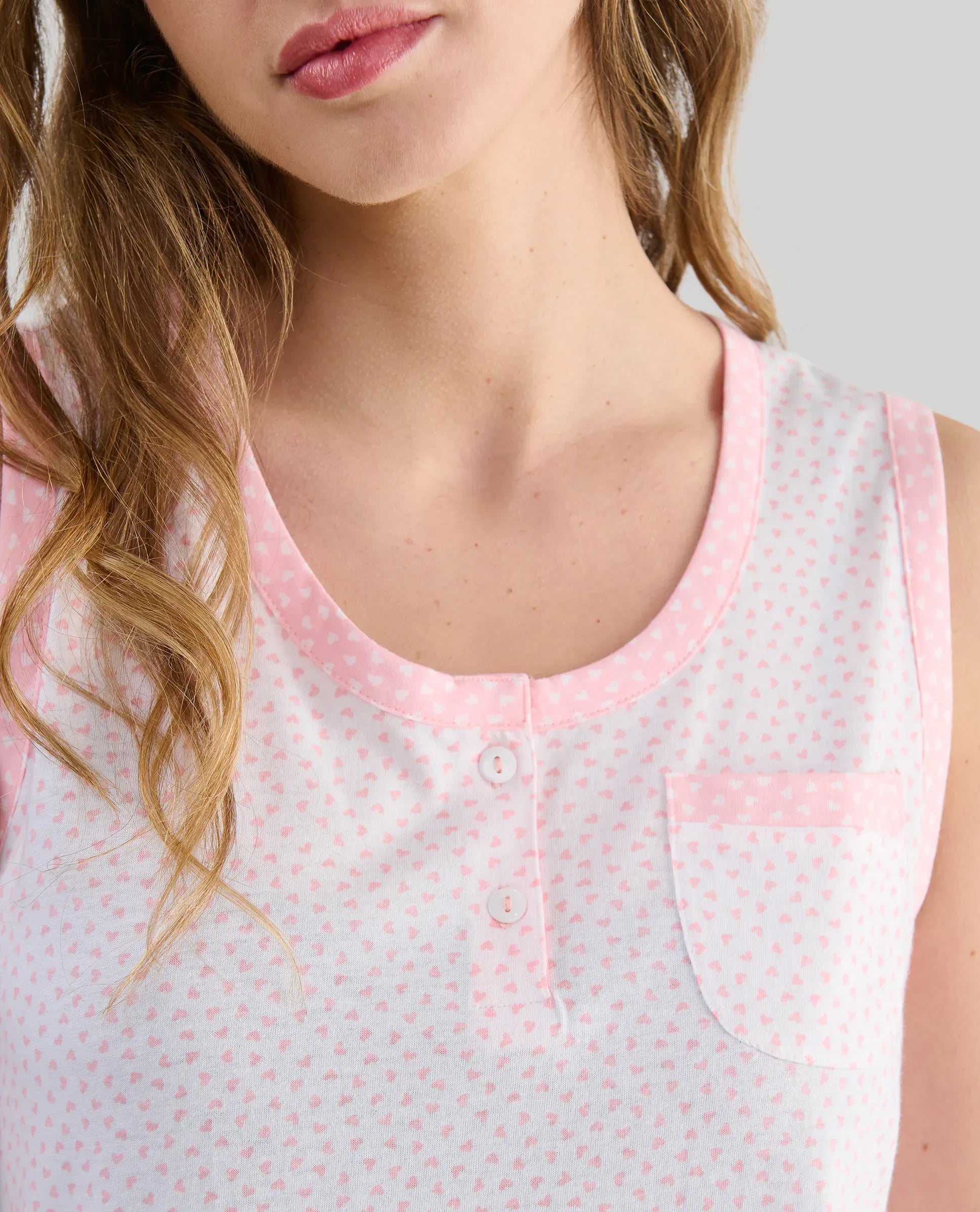Detalle del cuello abierto con pata de raso marino y botones rojos del pijama sin mangas de verano Lohe.