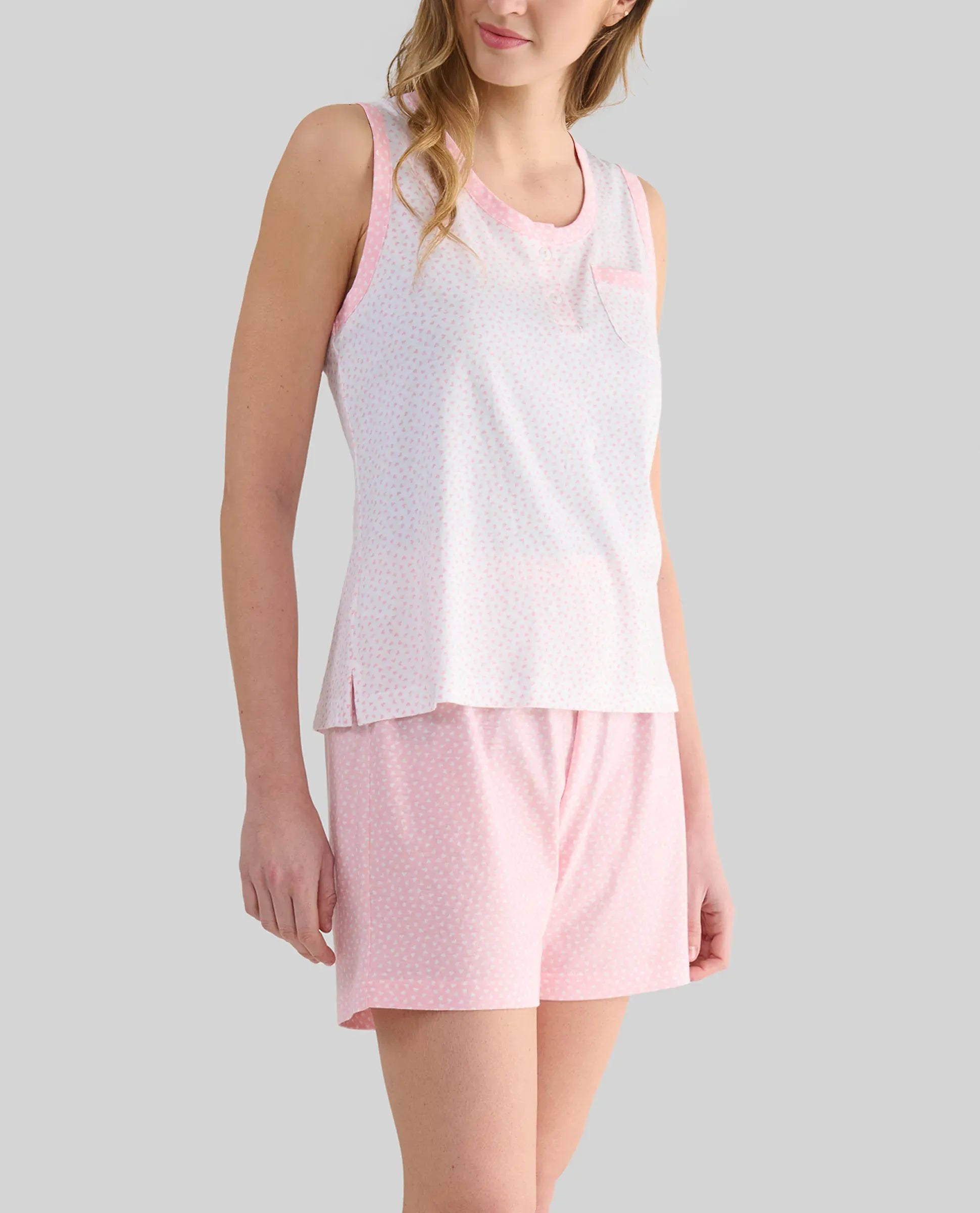 Mujer posa con pijama corto de verano de manga corta rosa con cuello abotonado y puntilla en cintura