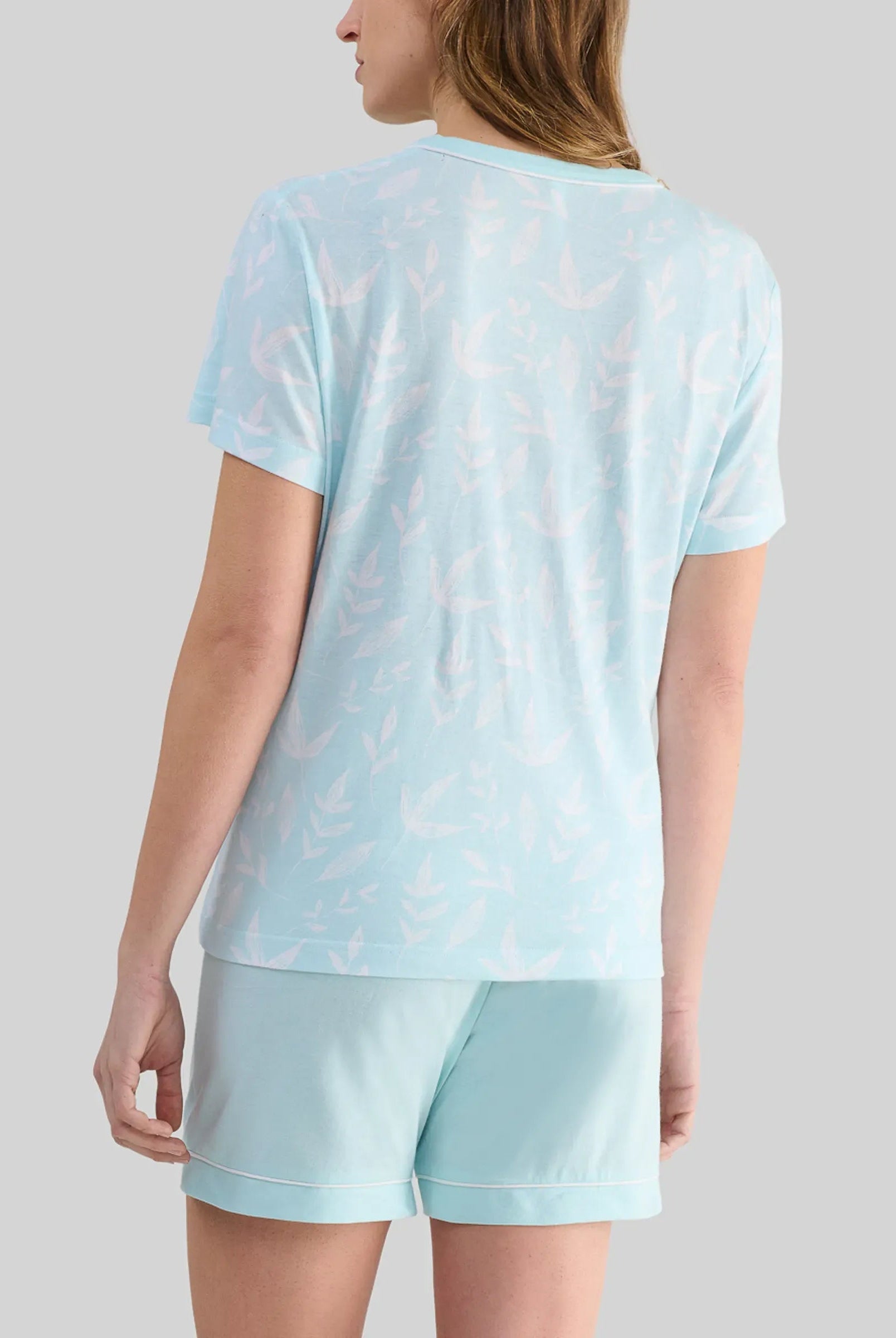 Trasera de mujer con pijama super fresco de verano en tonos verdes con estampado hojas