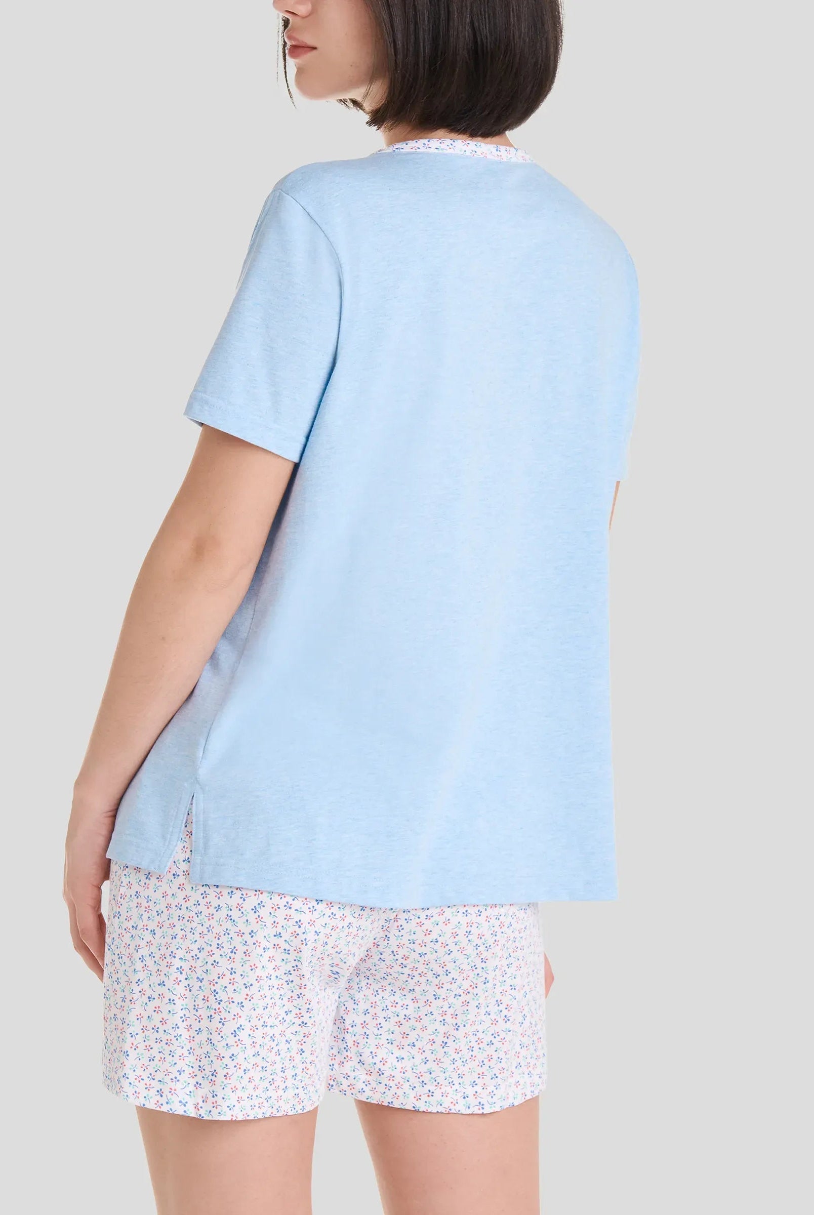 Mujer con pijama corto de manga corta, camiseta azul y pantalón corto de florecillas