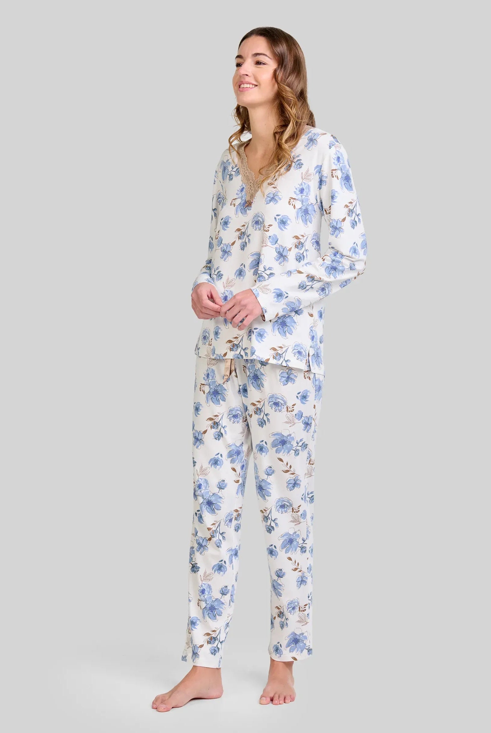 Mujer luce pijama de manga larga con estampado floral azul y escote en pico con detalle de encaje