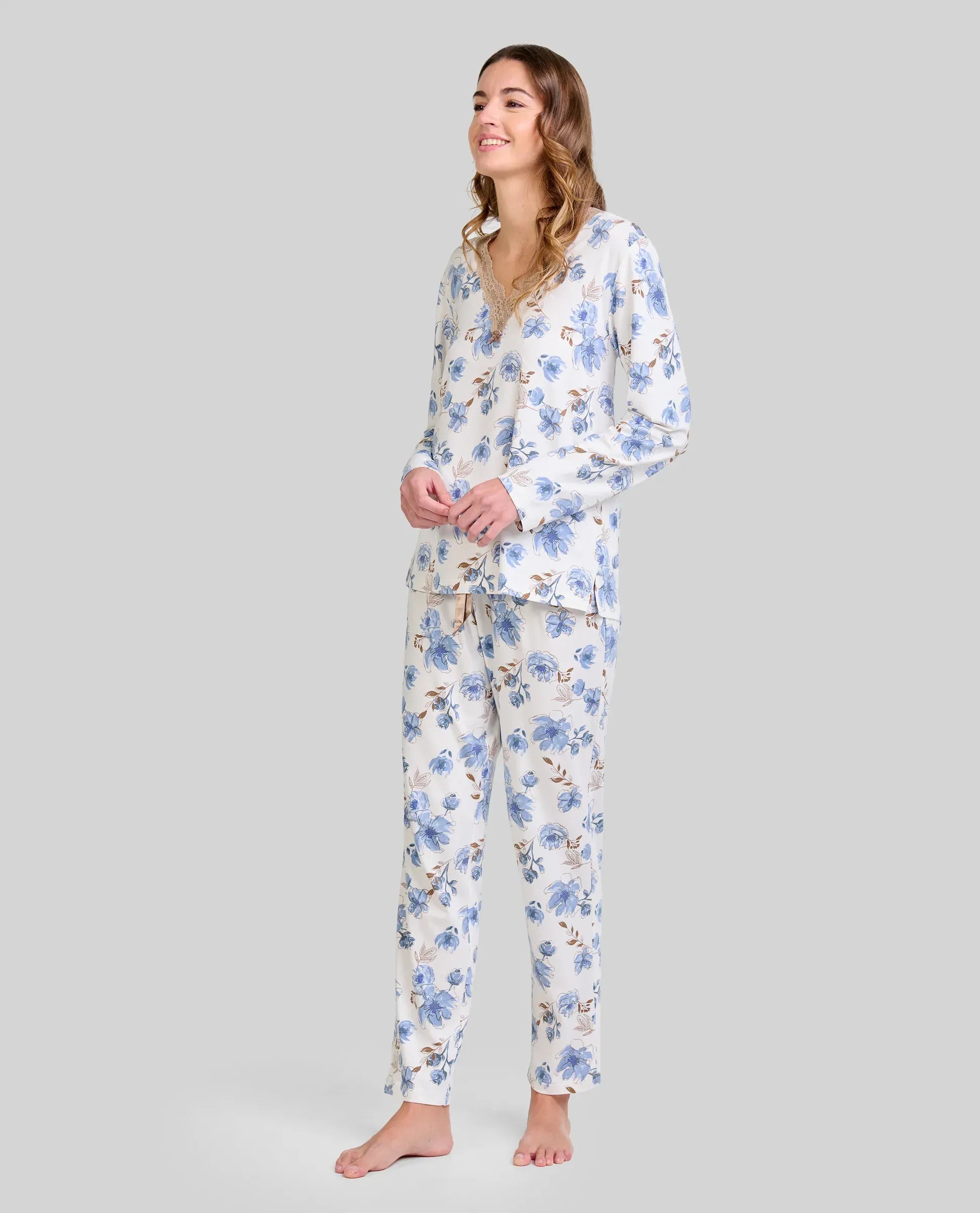 Mujer luce pijama de manga larga con estampado floral azul y escote en pico con detalle de encaje