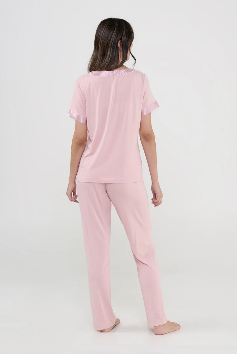 Mujer viste pijama de verano de manga corta en punto blanco y pantalón largo rosa con florecitas