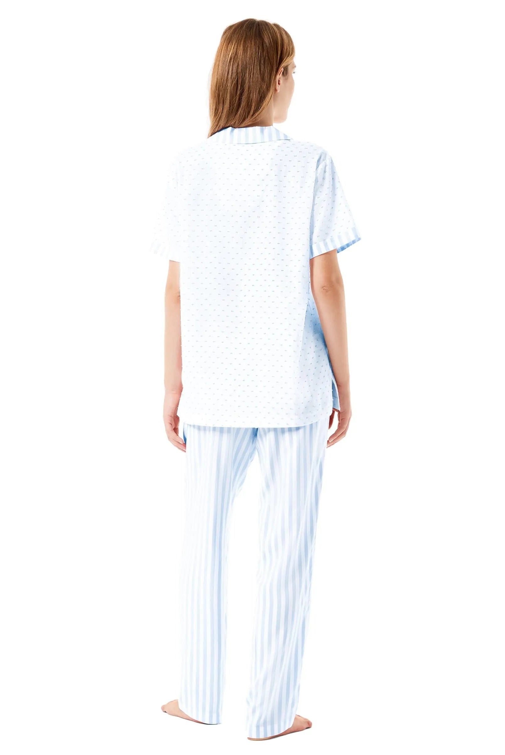 Mujer descansa con pijama largo marfil de estampado jacquard, chaqueta abierta con botones, bolsillos y pantalón largo.