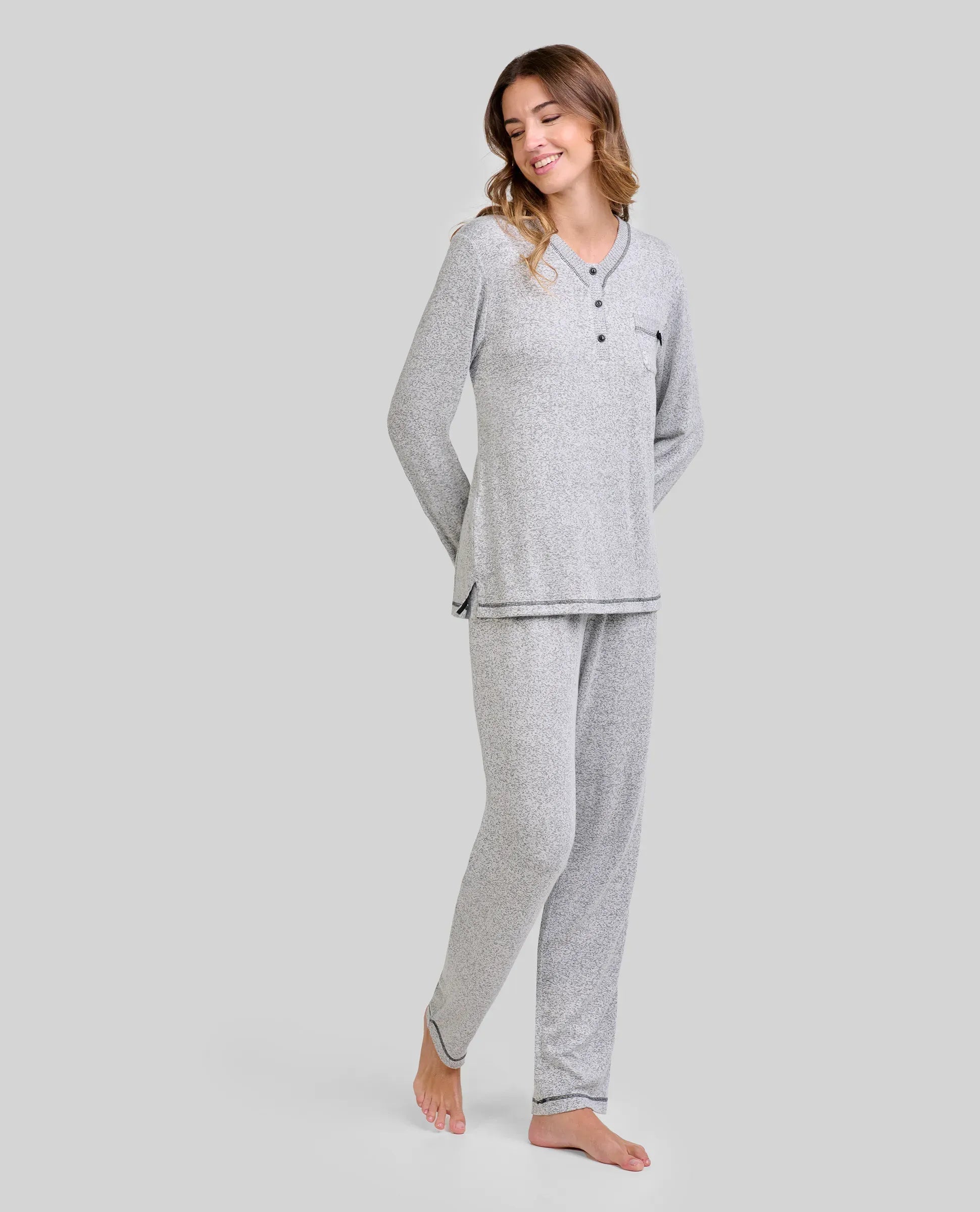 Mujer luciendo pijama gris de invierno de manga larga con cuello botones y bolsillo