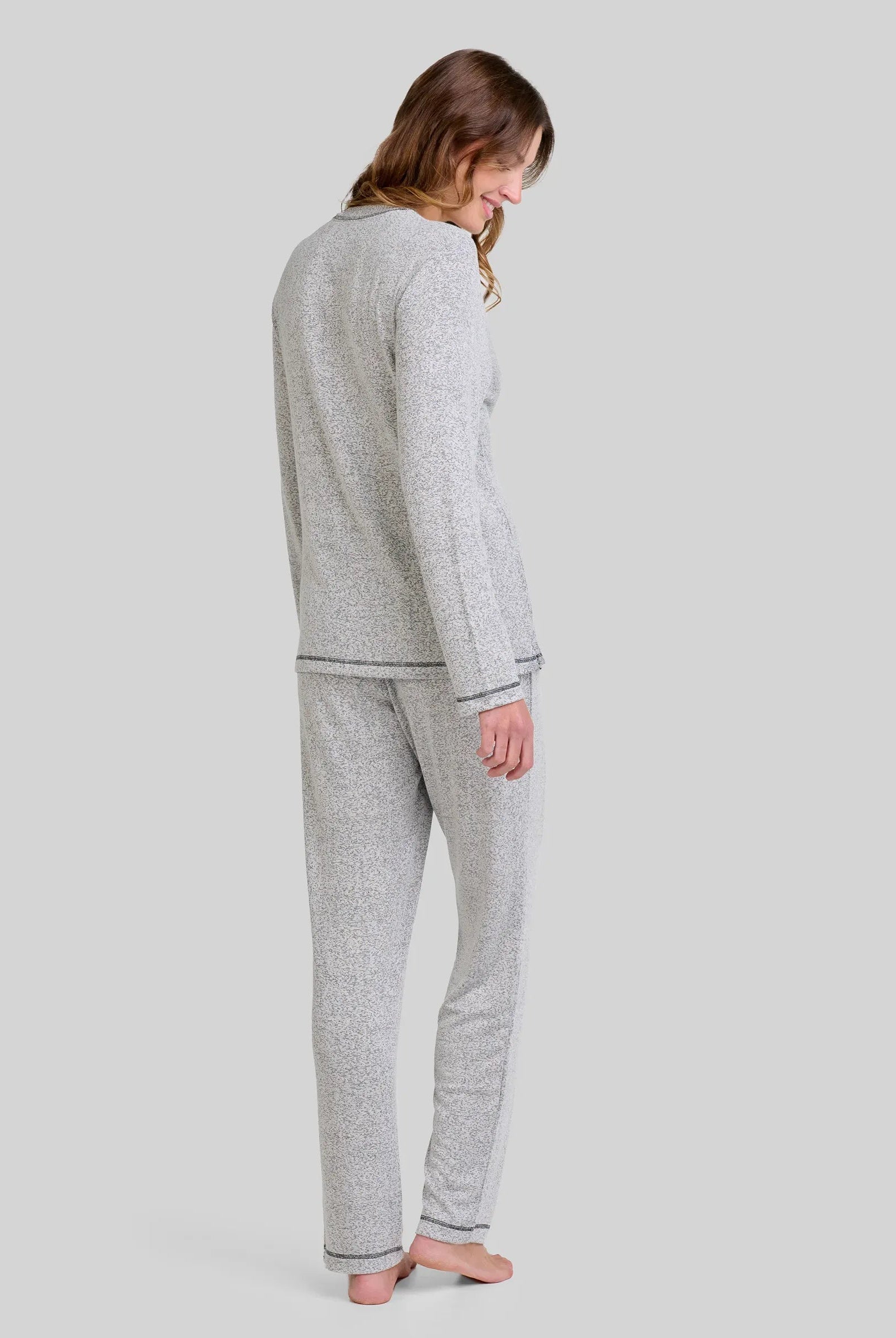 Mujer de espaldas con un pijama largo de agradable vigoré gris para invierno