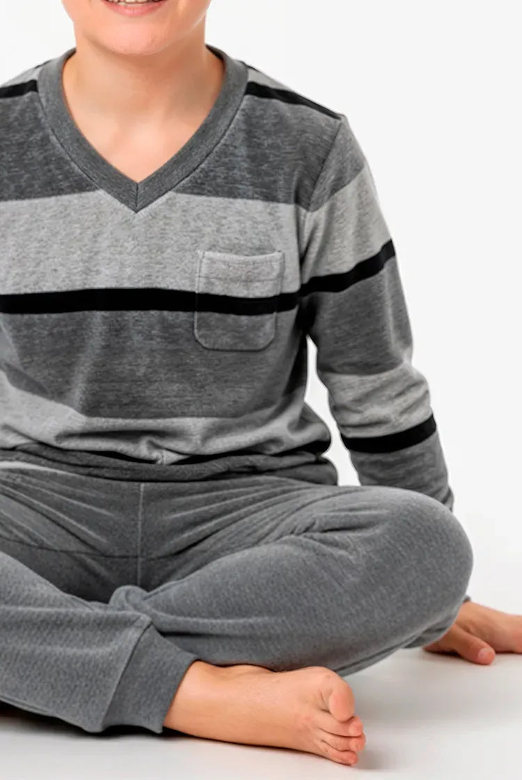 Vista detalle de niño con confortable pijama de invierno en terciopelo gris a rayas, cuello pico y puños elásticos