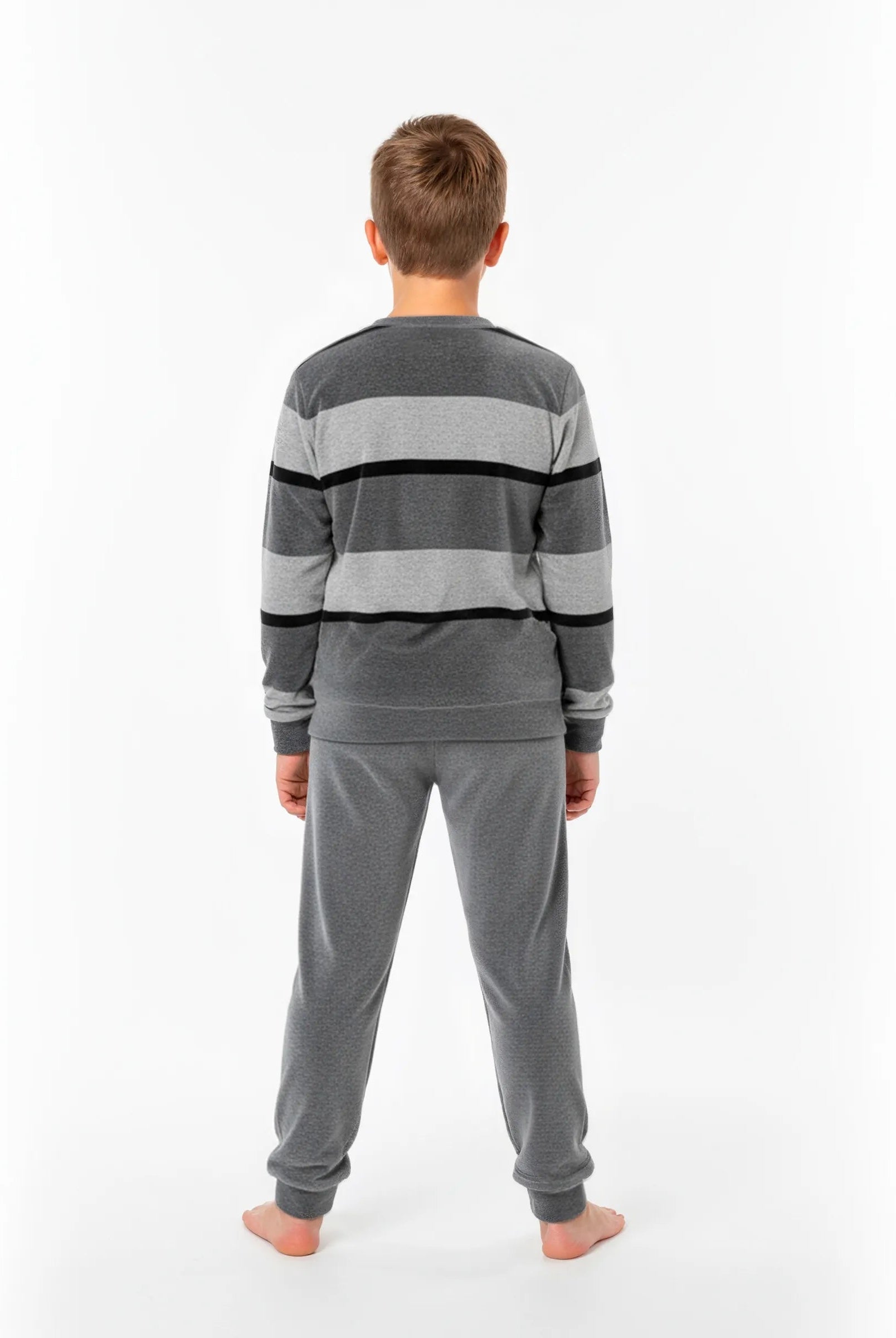 Niño de espaldas con pijama de invierno de terciopelo gris a rayas y puños elásticos
