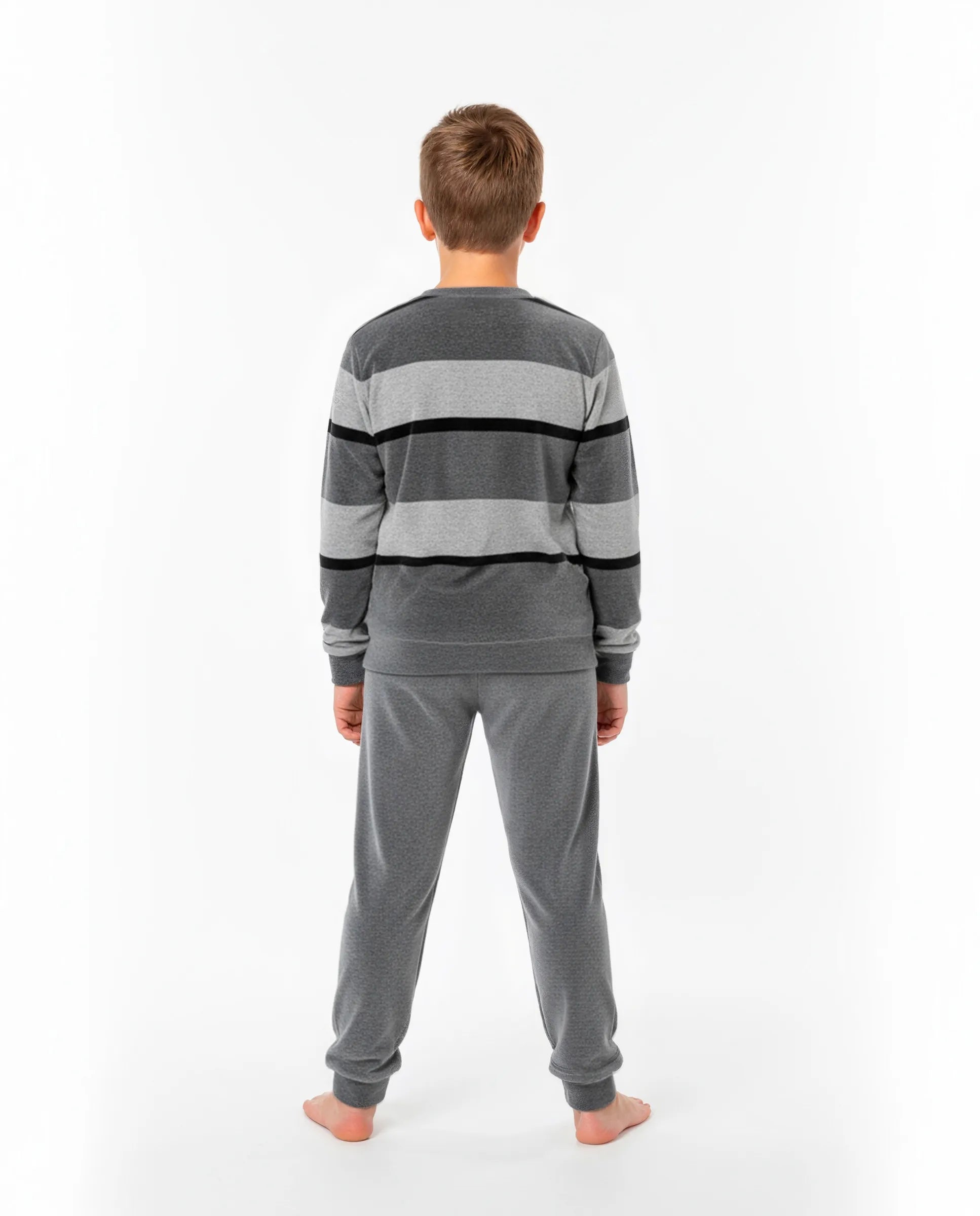Niño de espaldas con pijama de invierno de terciopelo gris a rayas y puños elásticos