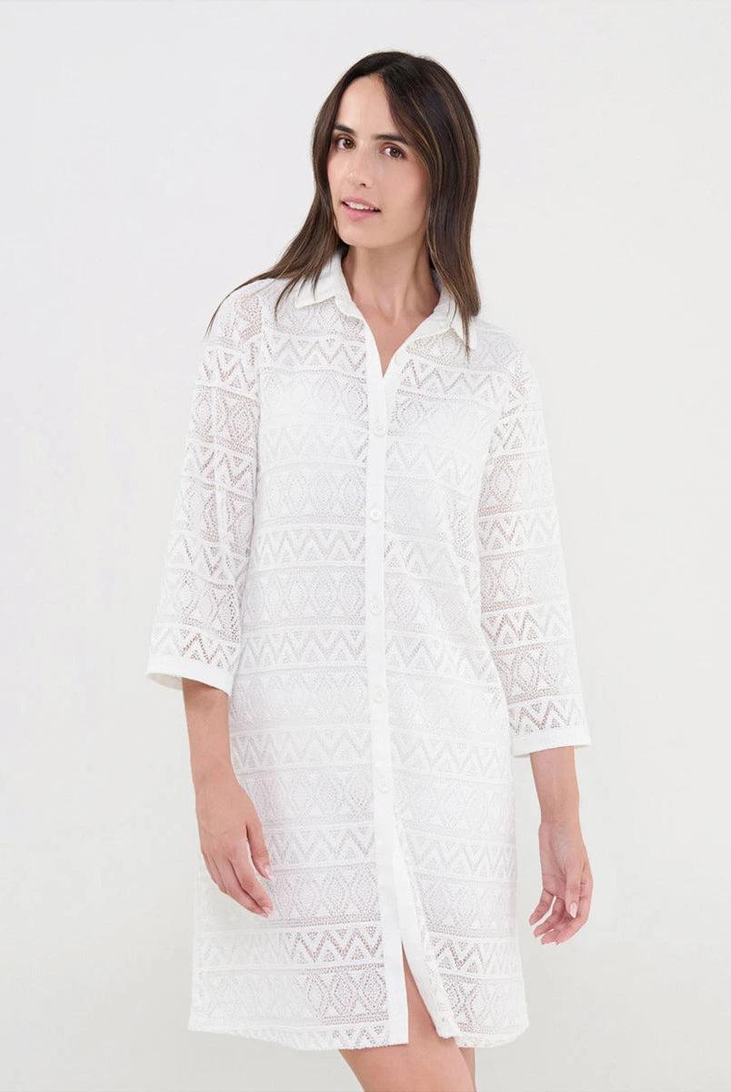 Mujer luciendo vestido turquesa de manga corta con bordados geométricos intrincados y cuello abierto con pata y botones