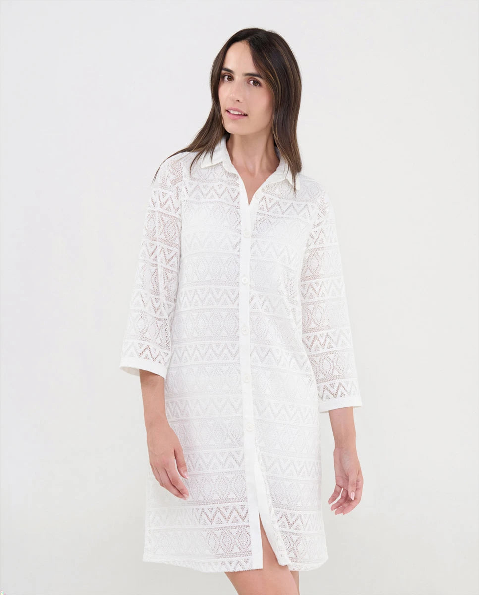 Mujer luciendo vestido turquesa de manga corta con bordados geométricos intrincados y cuello abierto con pata y botones