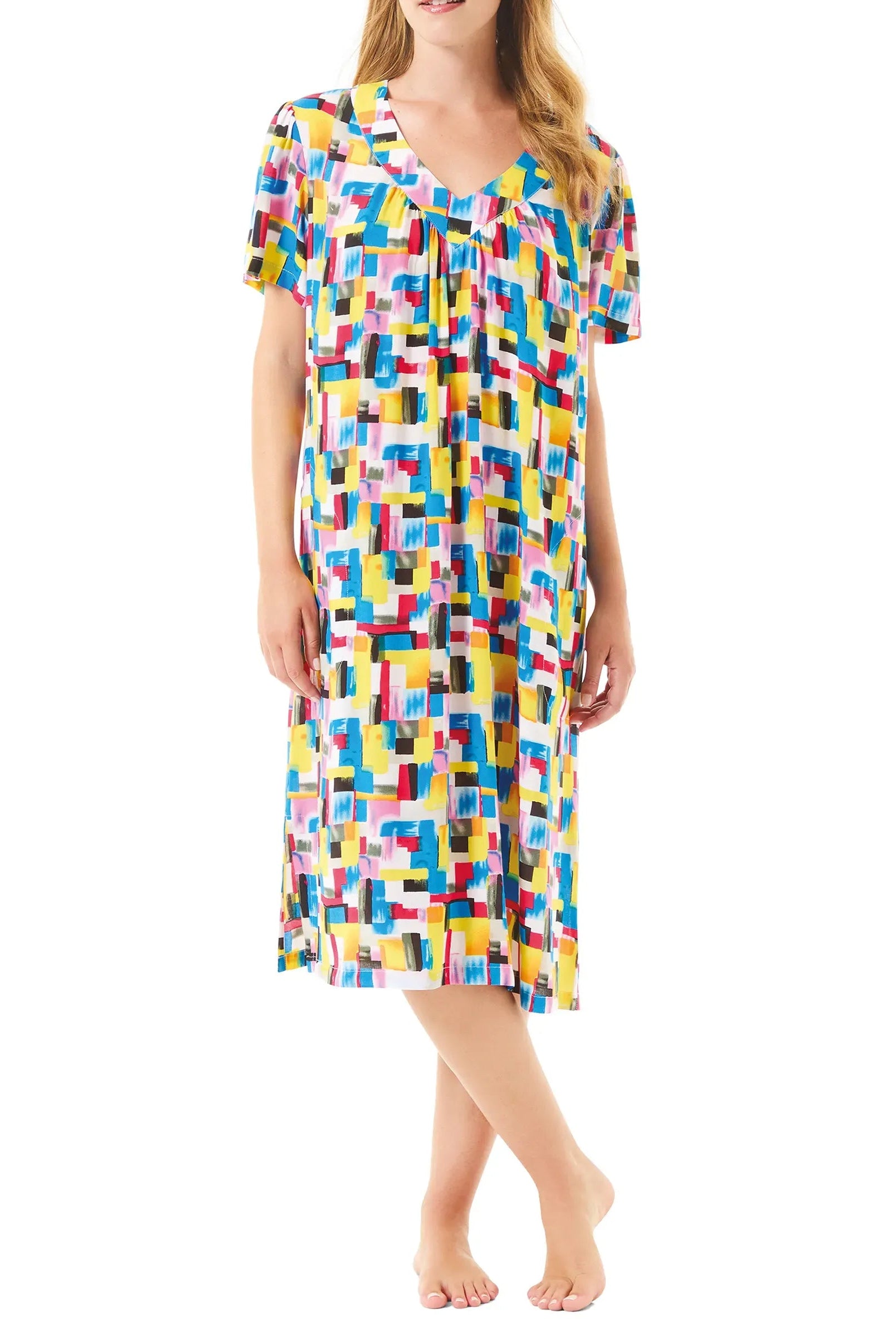 Mujer luce vestido de verano de manga corta y colorido estampado geométrico