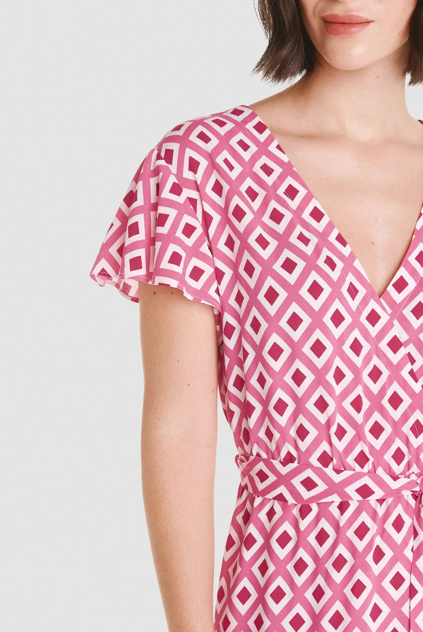 Modelo luce vestido corto de verano de escote cruzado y cinturón en estampado rojo de rombos