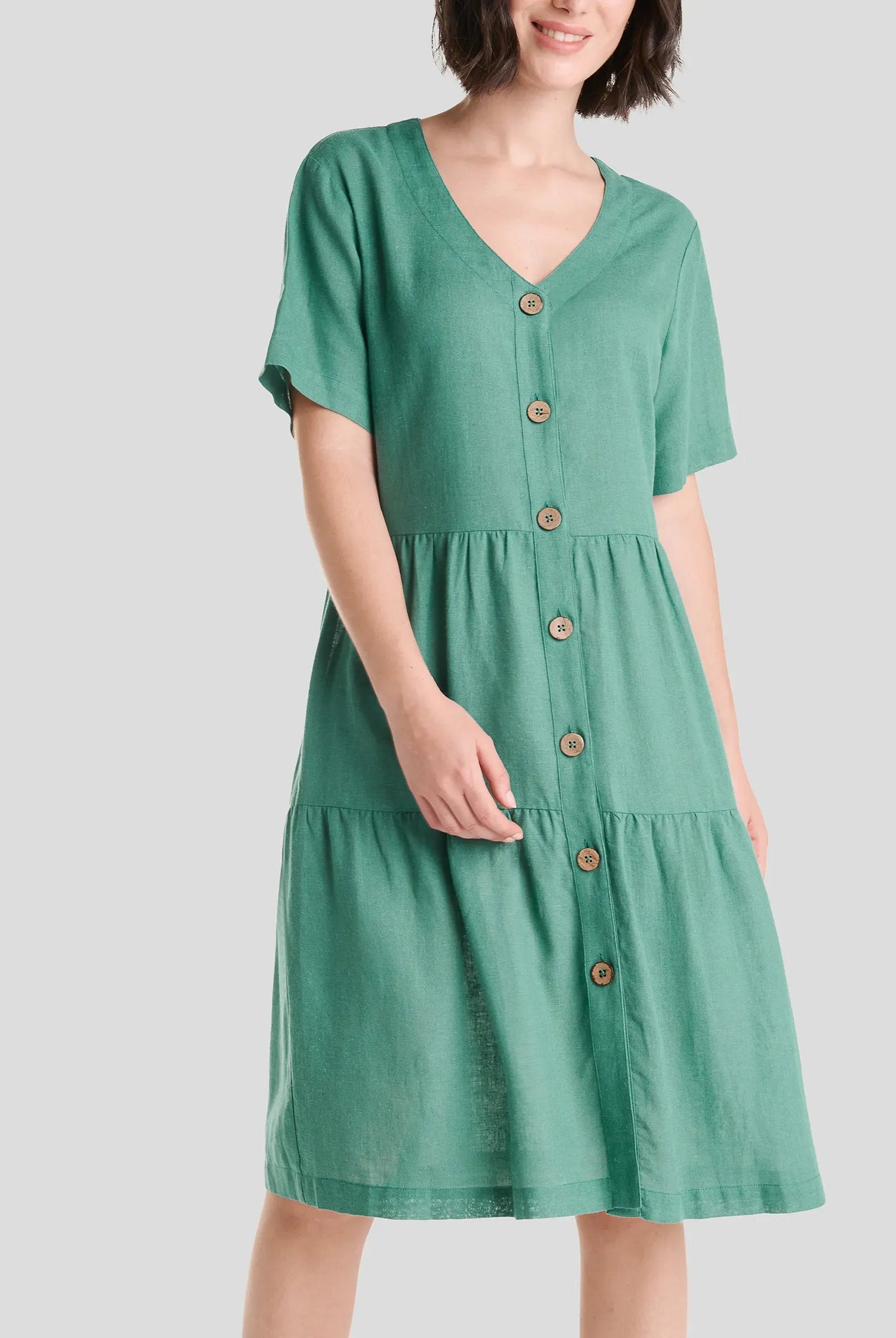 Mujer con Vestido corto de verano verde abotonado sin cuello y manga corta.