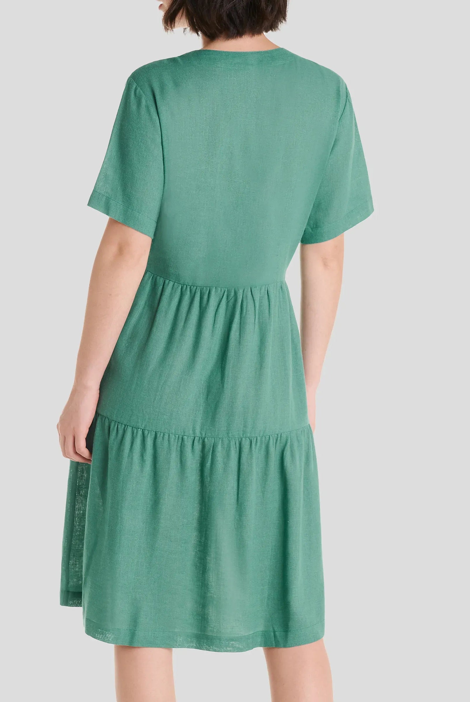 Vista trasera de vestido corto de verano de lino verde de manga corta