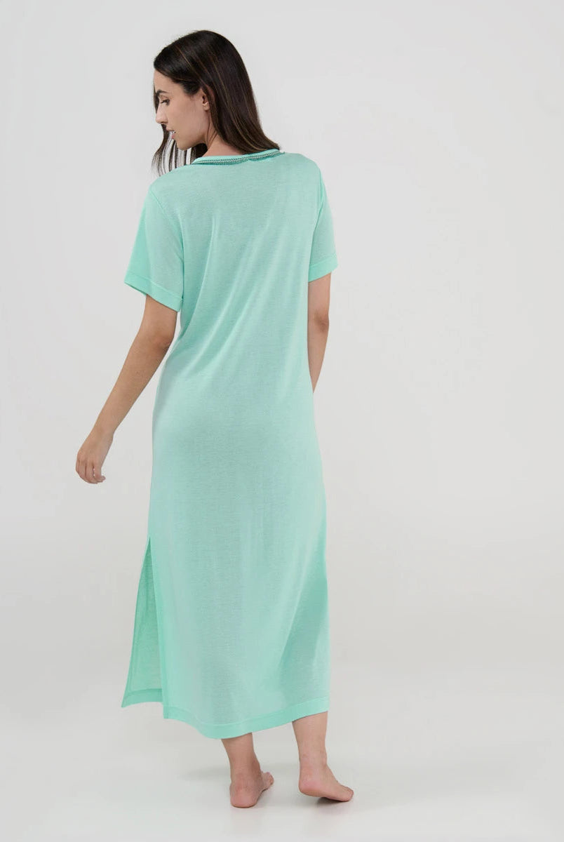 Mujer de espaldas con vestido playero largo verde menta y manga corta