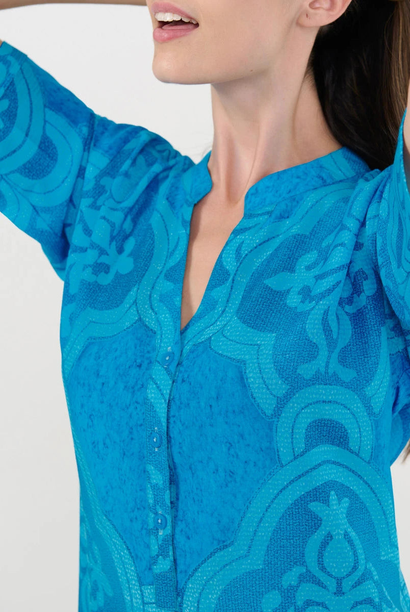 Detalle del cuello abierto con pata y botones del vestido playero turquesa