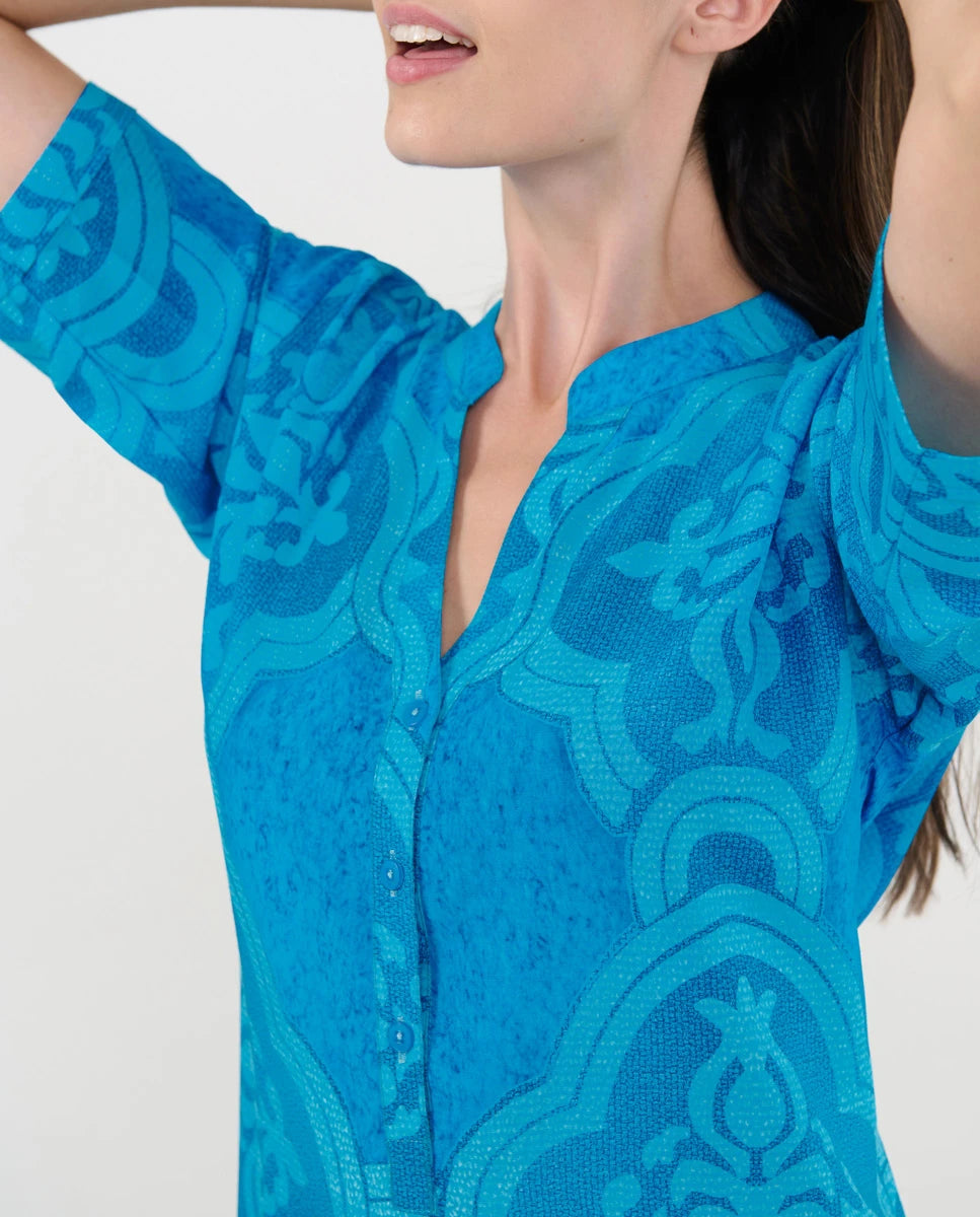 Detalle del cuello abierto con pata y botones del vestido playero turquesa