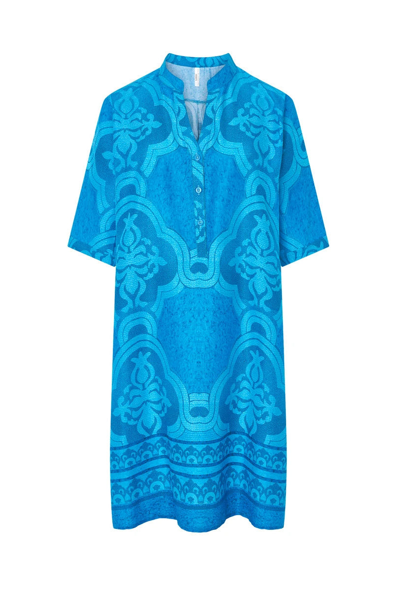 Vestido de baño de mujer de manga corta azul con estampado mosaico y cuello abierto con pata y botones.