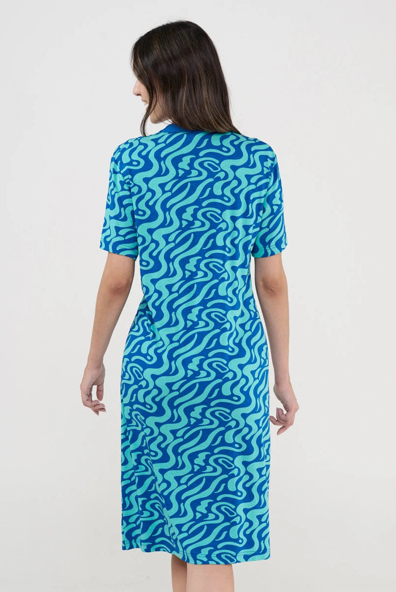 Vista de espaldas de mujer con vestido playero de manga corta azul estampado ondas