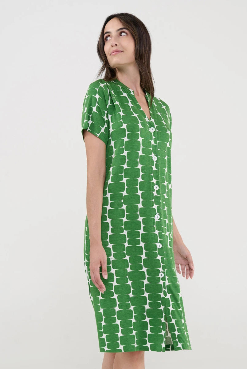 Mujer con vestido playero verde de manga corta abotonado y patrón geométrico blanco.