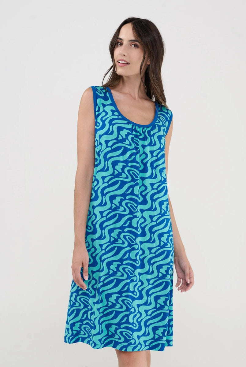 Mujer con vestido playero corto sin mangas en punto azul estampado ondas con cuello redondo y boslillos