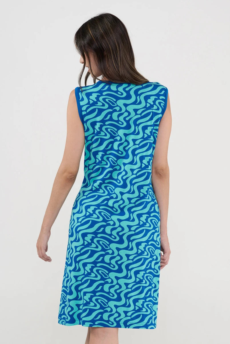 Modelo posa de espaldas con vestido playero corto sin mangas azul estampado ondas