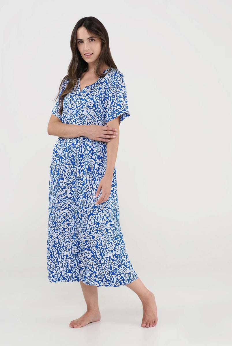 Mujer con vestido playero midi azul y blanco de estampado floral, manga corta y escote en V.
