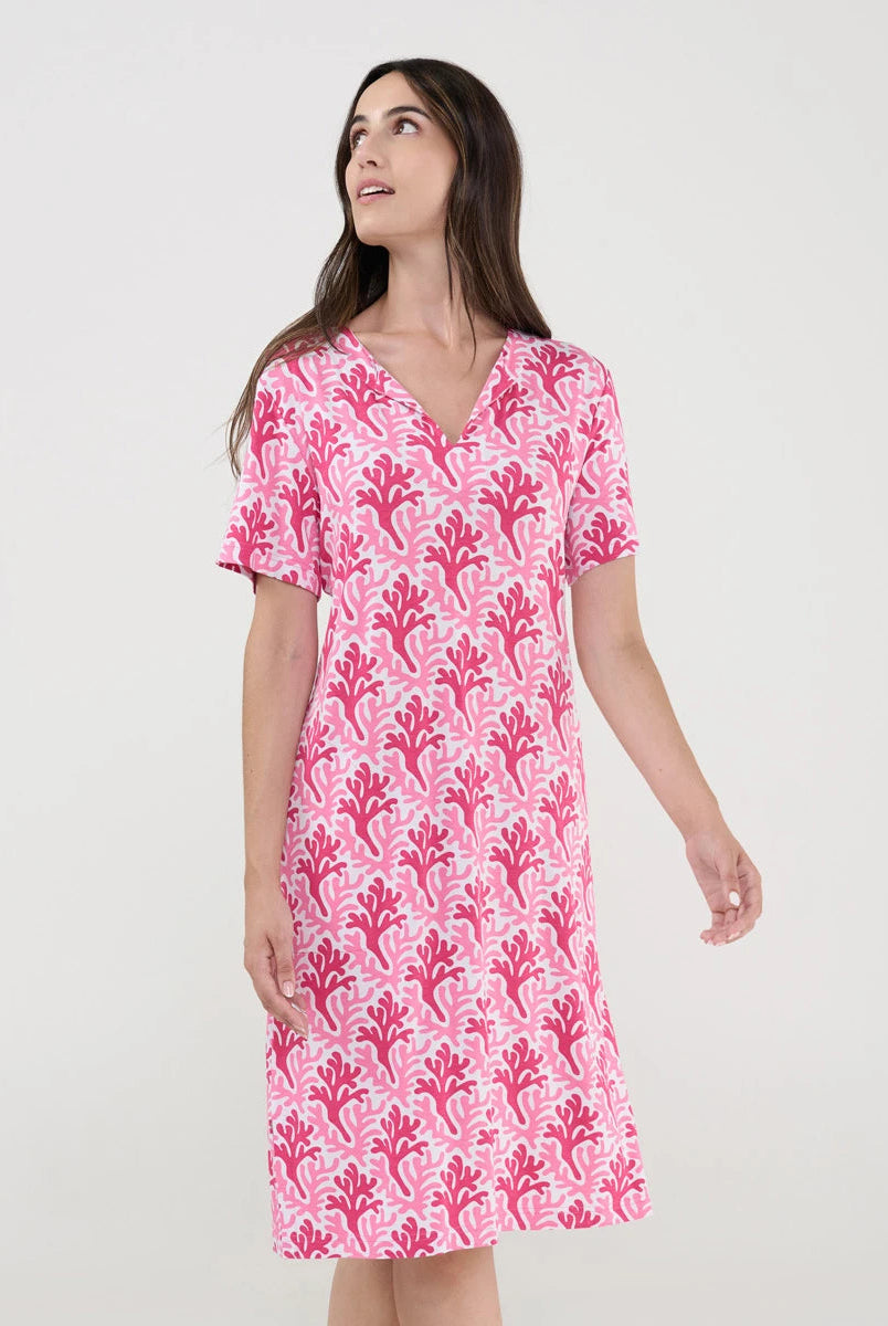 Mujer con vestido de baño corto de manga corta y estampado fucsia de corales