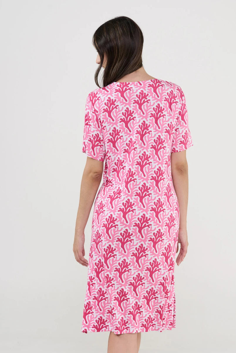 Mujer de espaldas luce cómodo vestido playero estampado fucsia