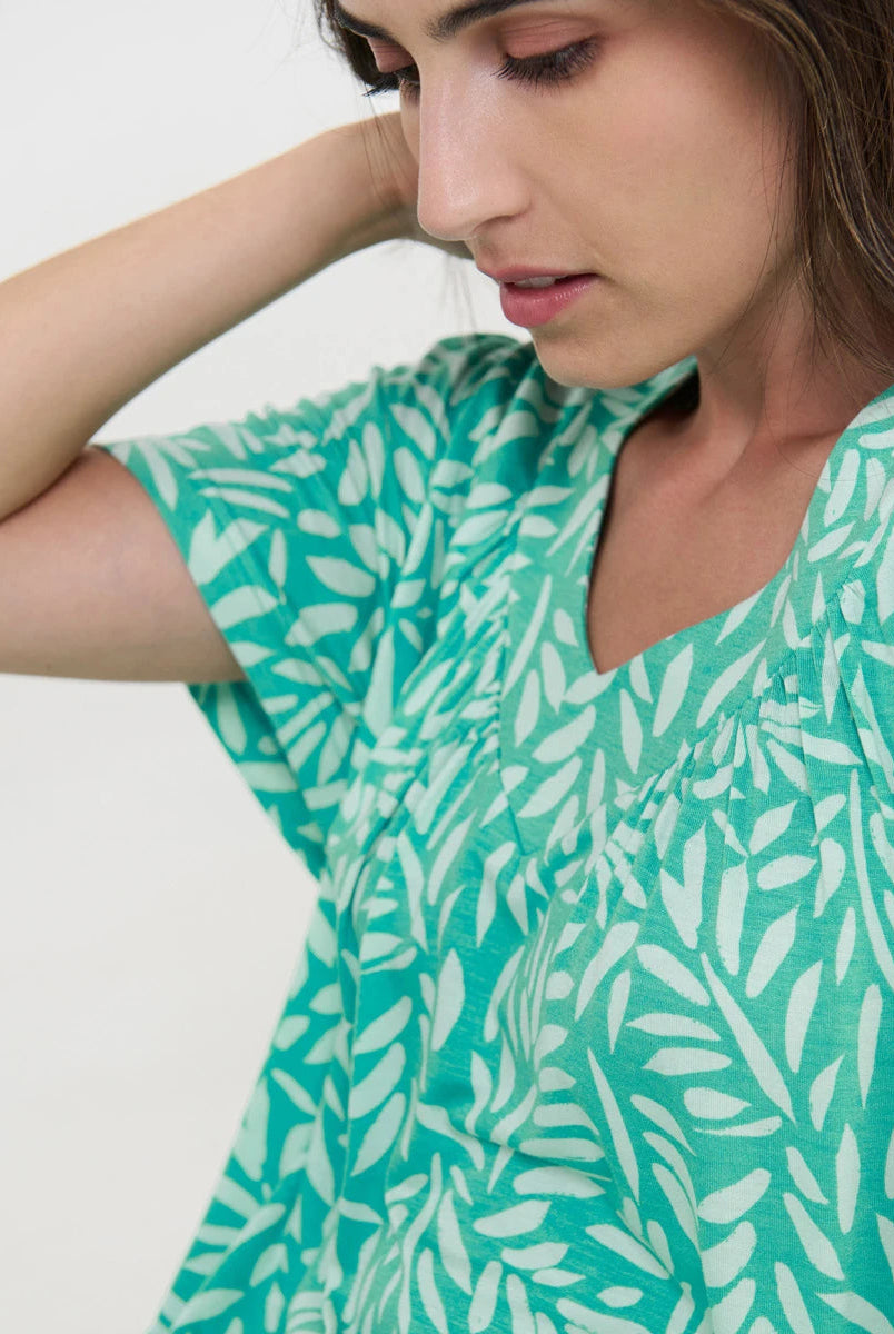 Detalle del escote en v del vestido playero color verde con estampado de hojas