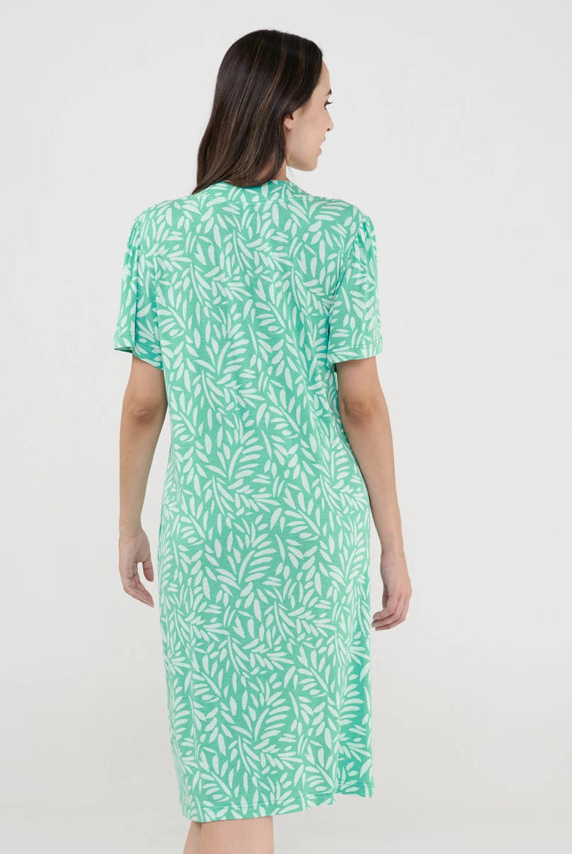 Mujer con vestido de verano corto verde con estampado de hojas vista de espaldas