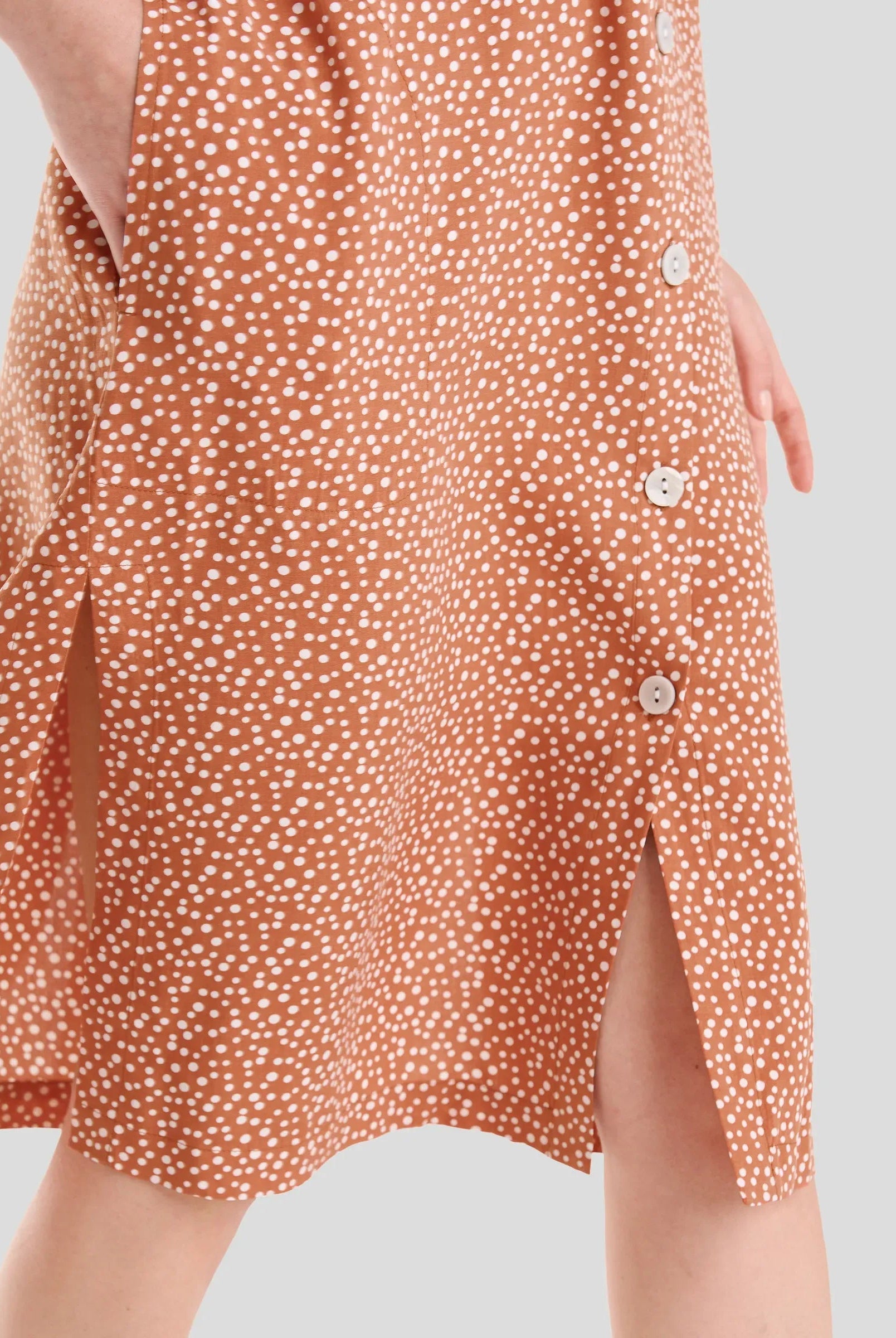 Detalle del vestido veraniego abierto con botones en viscosa naranja caldero a topitos, super fresco