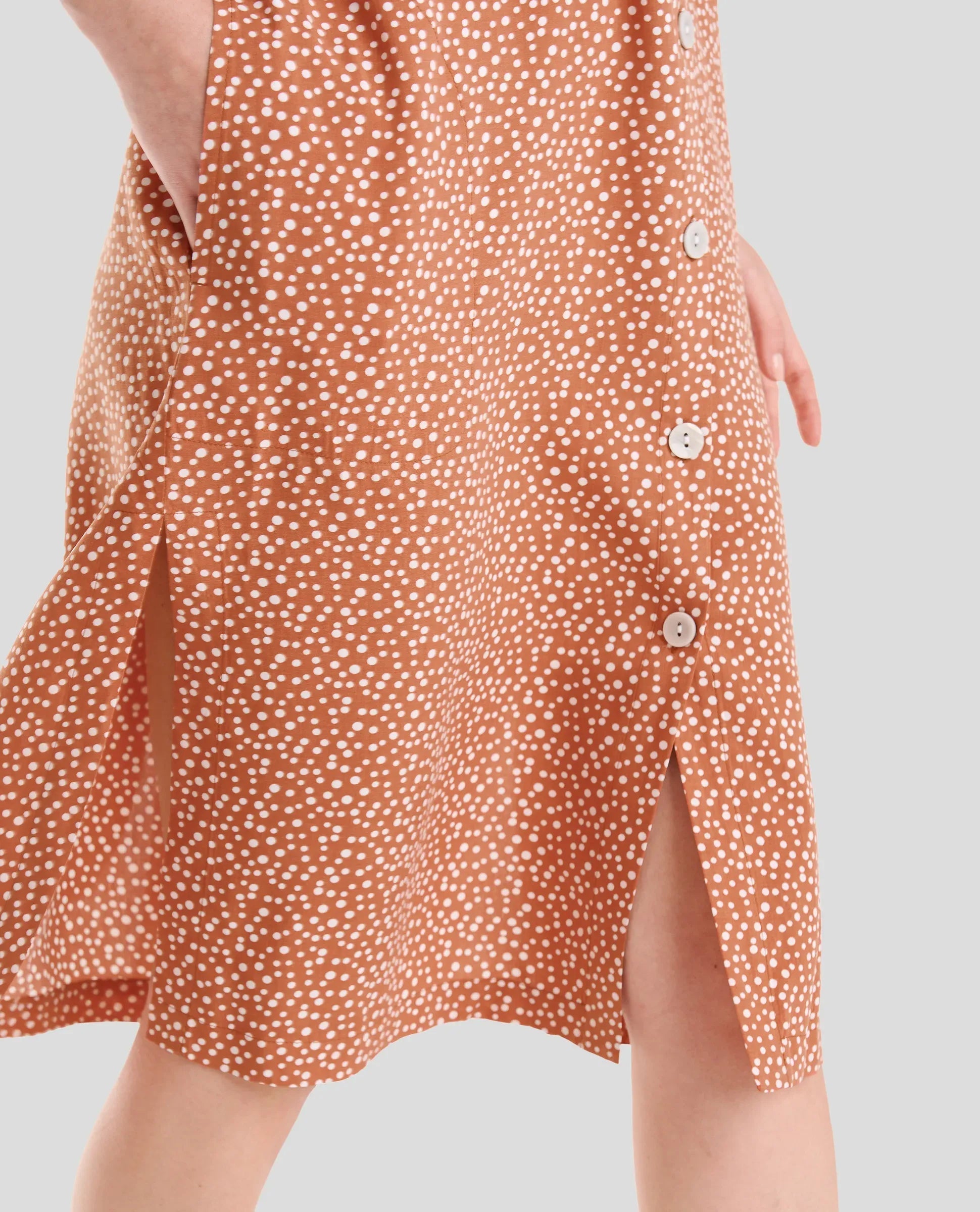 Detalle del vestido veraniego abierto con botones en viscosa naranja caldero a topitos, super fresco