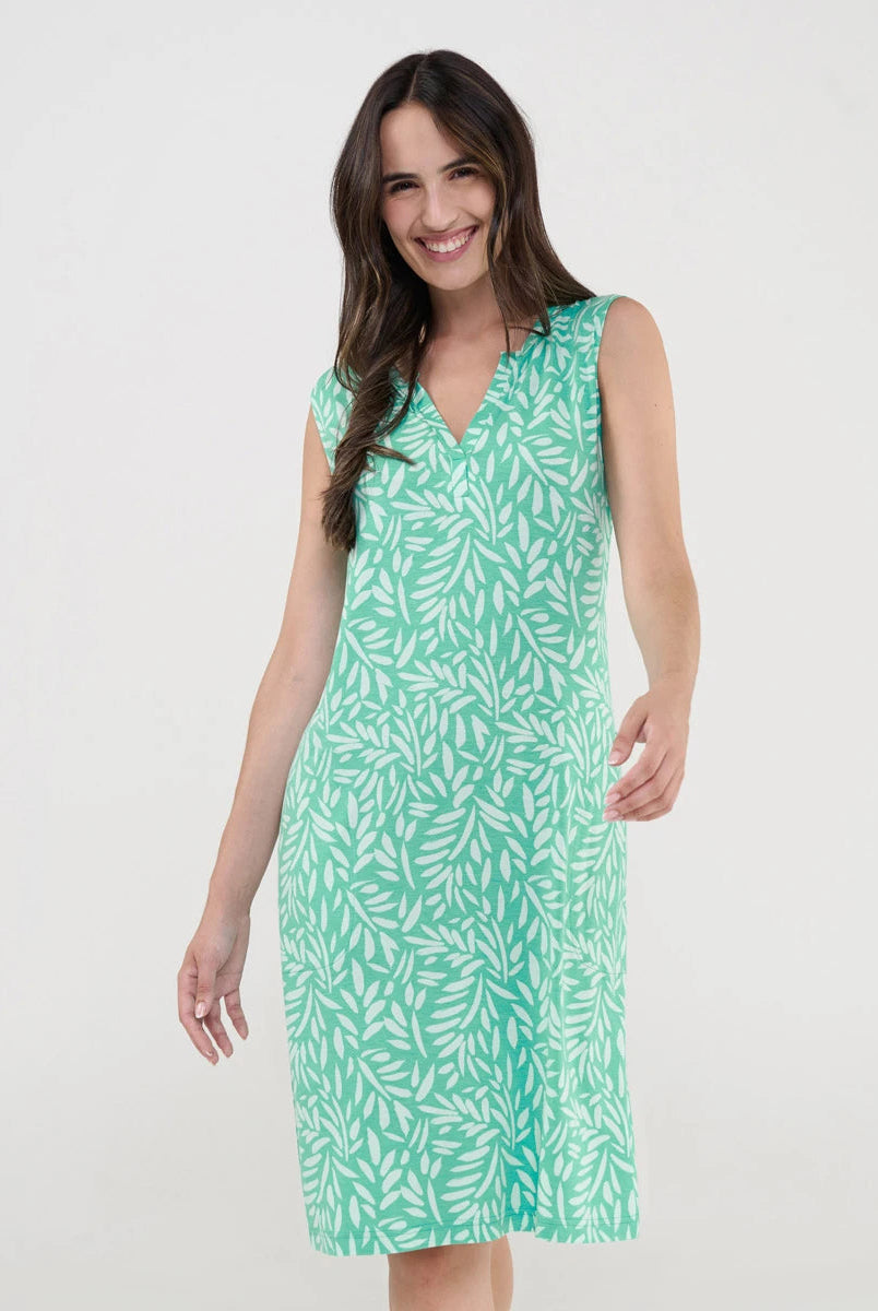 Mujer luce vestido corto de playa sin mangas verde estampado hojas blancas