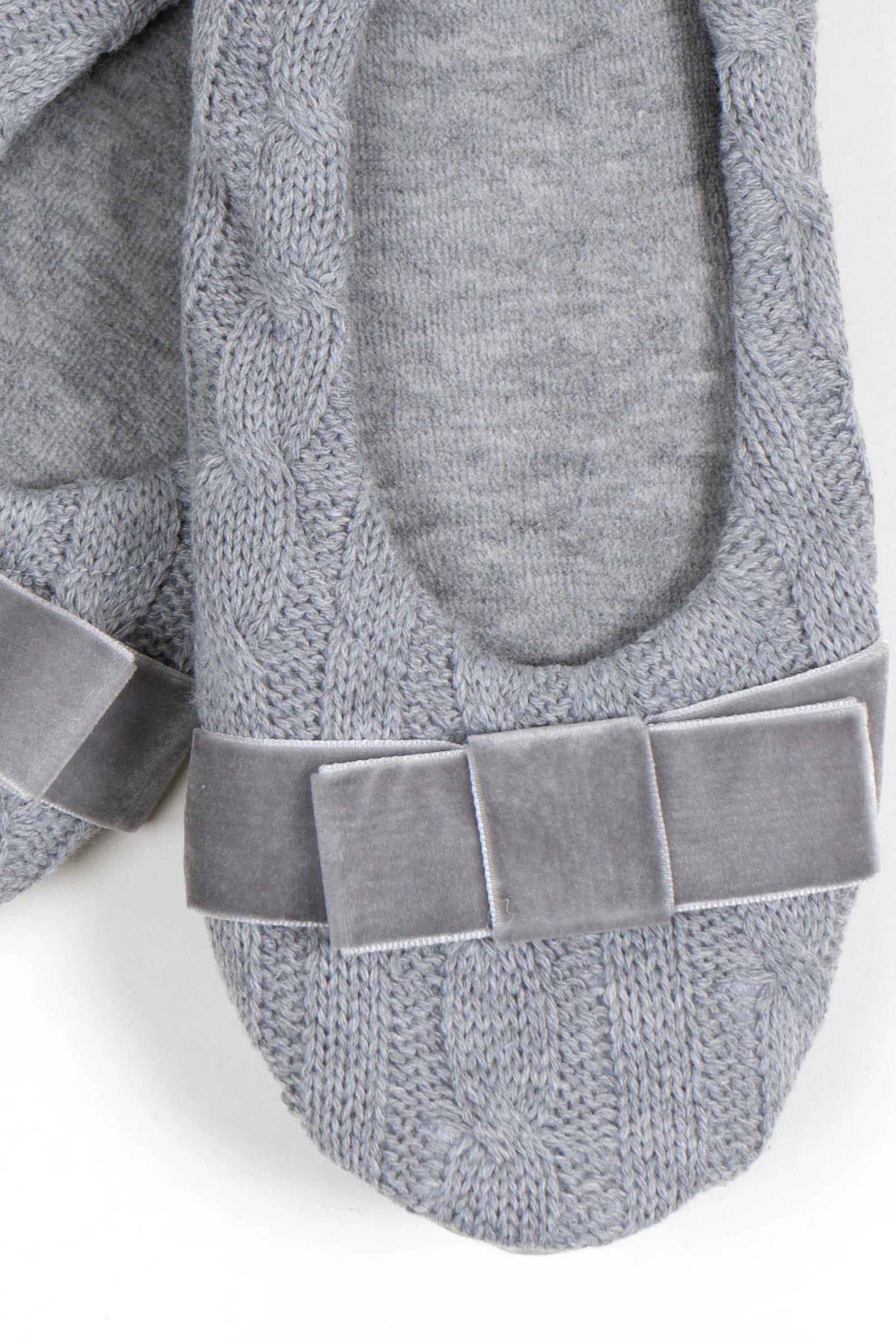 Detalle de lazo en terciopelo de las zapatillas de casa para mujer de tejido trenzado